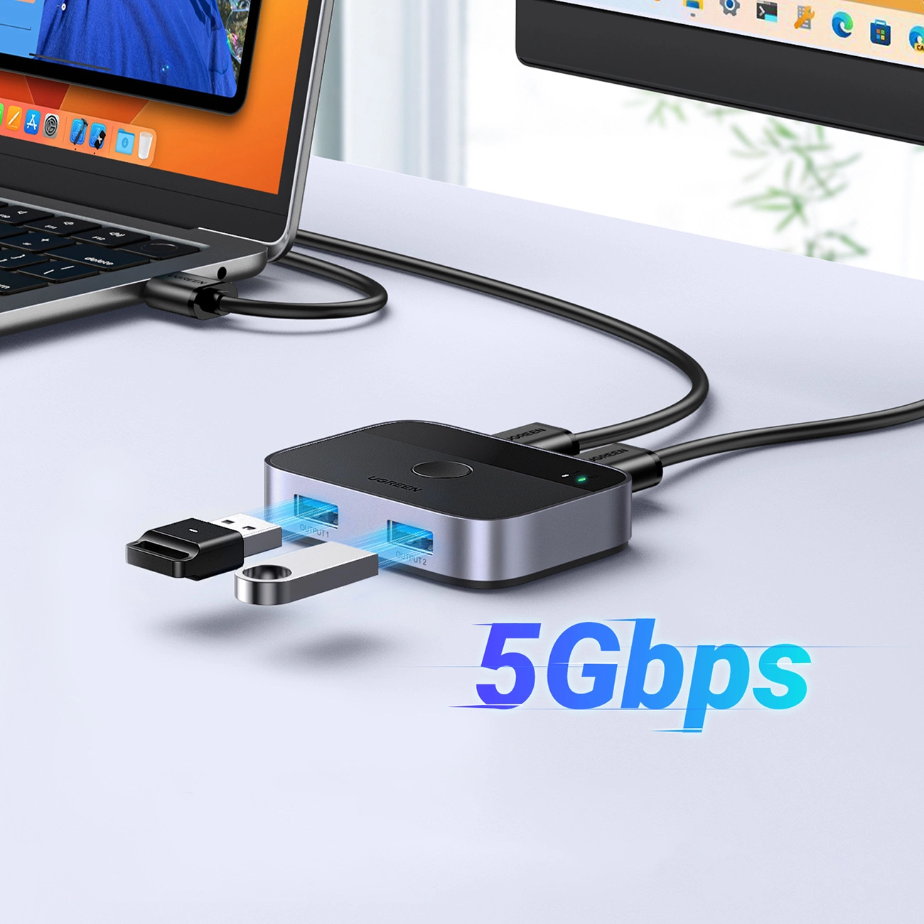 Srebrny i czarny hub USB łączy się z laptopem i monitorem. Dysk USB jest podłączony. Widoczny jest tekst '5Gbps'.
