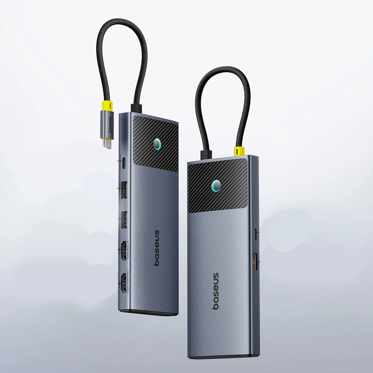 Zwei Baseus USB-C-Hubs, grau mit Kohlefaser-Oberteilen und schwarz geflochtenen Kabeln. Eines hat gelbe Akzente. Weißer Hintergrund.
