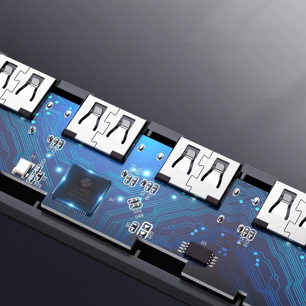Primo piano di un hub USB. Porte USB argentate su un circuito stampato blu con componenti elettronici, su sfondo scuro.