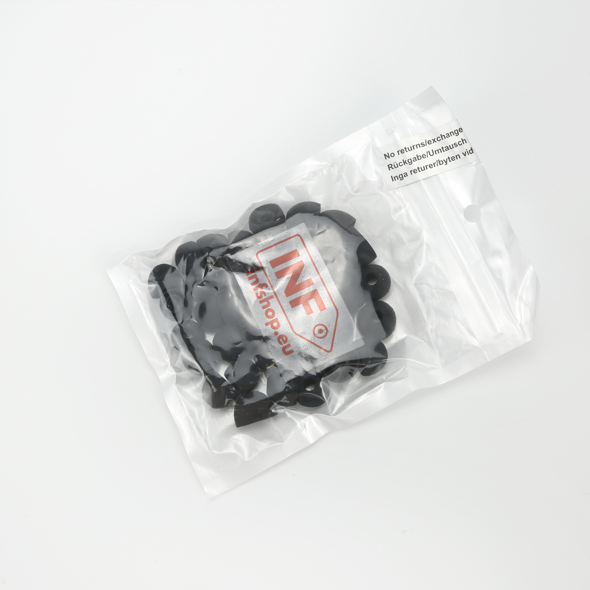 Przezroczysta plastikowa torba zawierająca czarne gumowe pierścienie. Torba ma etykietę z tekstem. Tło jest białe.