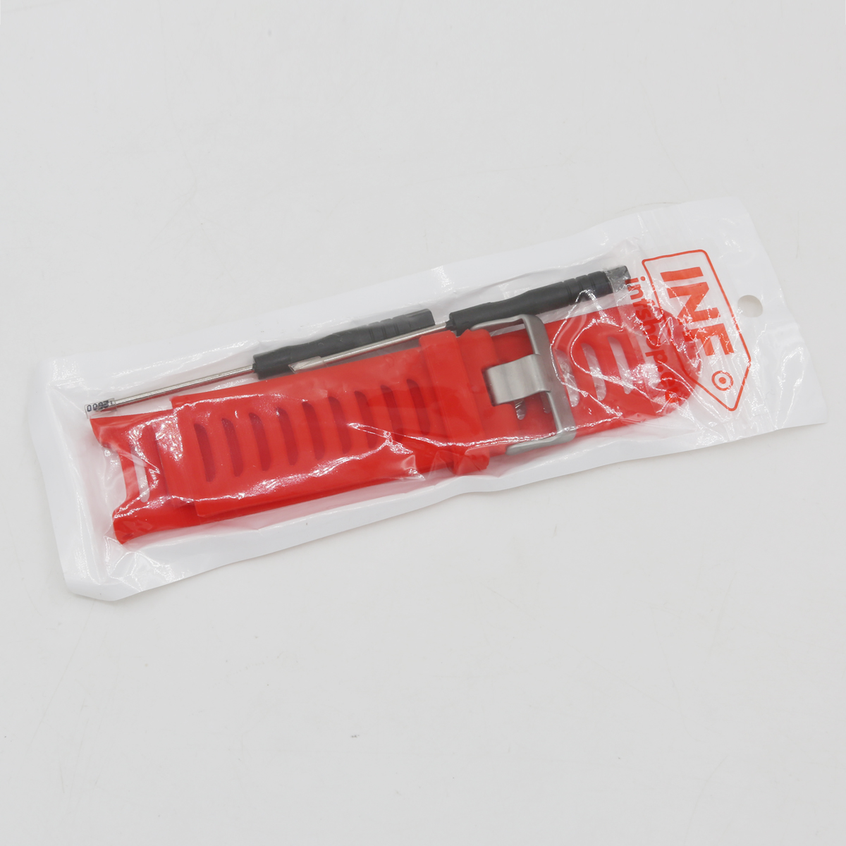 Ein rotes Uhrenarmband und Werkzeuge in einer transparenten Plastikverpackung auf weißem Untergrund. Das Armband ist sichtbar.
