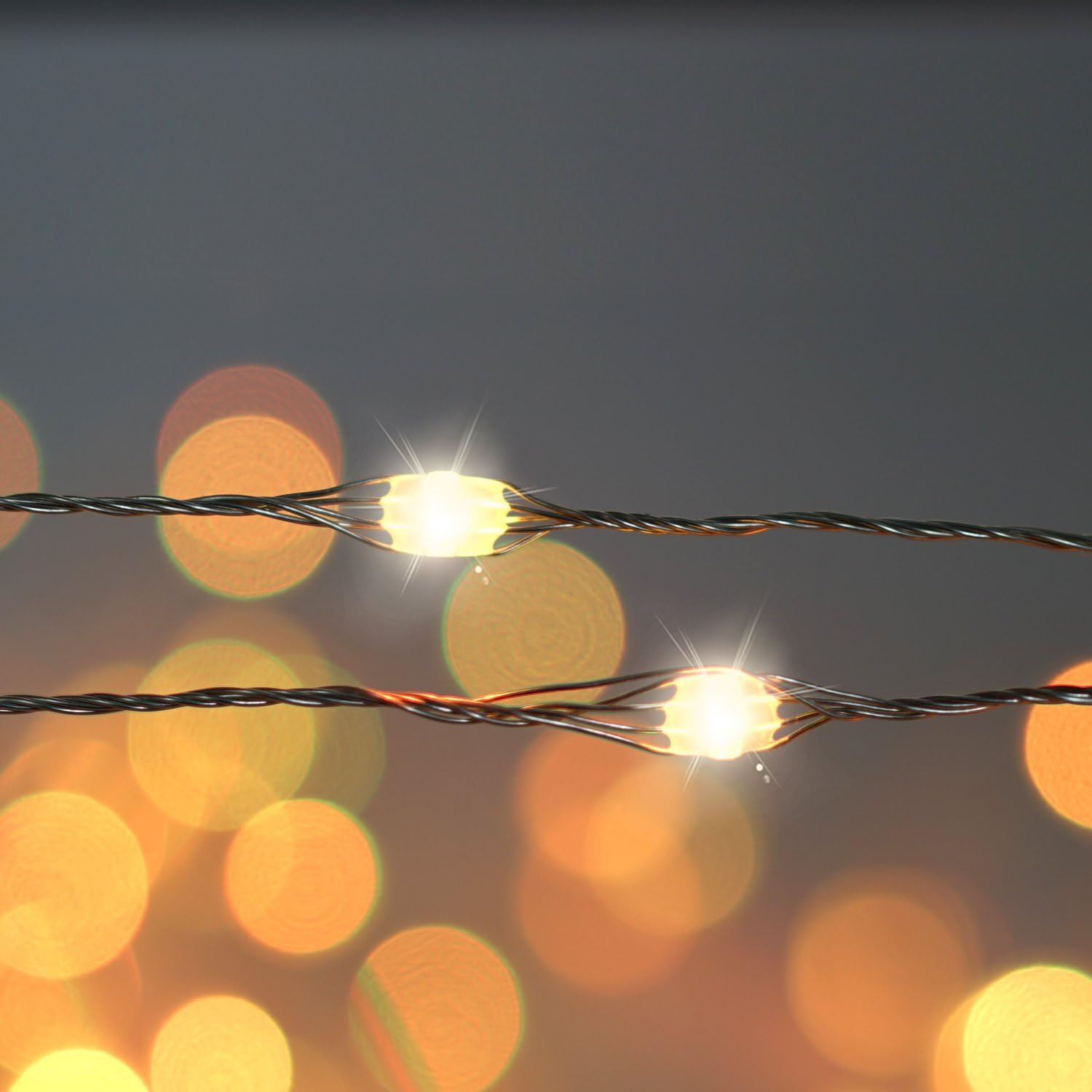 Nahaufnahme von Lichterketten. Zwei Stränge mit hellen Glühbirnen. Bokeh-Effekt im Hintergrund mit verschwommenen, warmen Lichtkreisen.