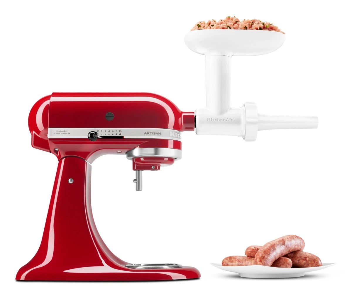 Ein roter KitchenAid-Mixer mit einem weißen Fleischwolf-Aufsatz. Gehacktes Fleisch befindet sich im Fleischwolf, Würste auf einem Teller.