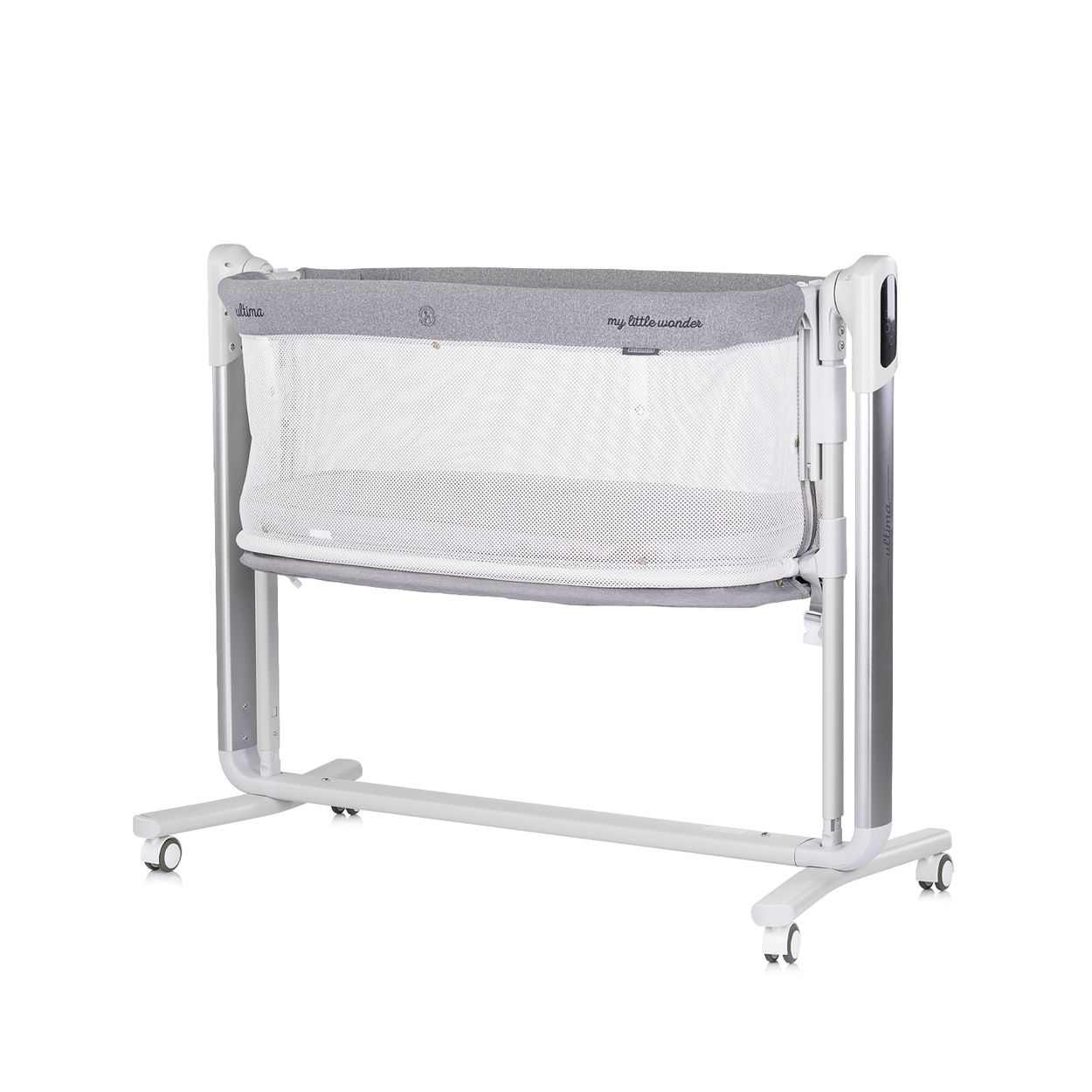 Ein grau-weißes Babybett mit Rädern. Es hat eine Netzseite und eine gepolsterte Oberseite. Das Bett steht vor weißem Hintergrund.