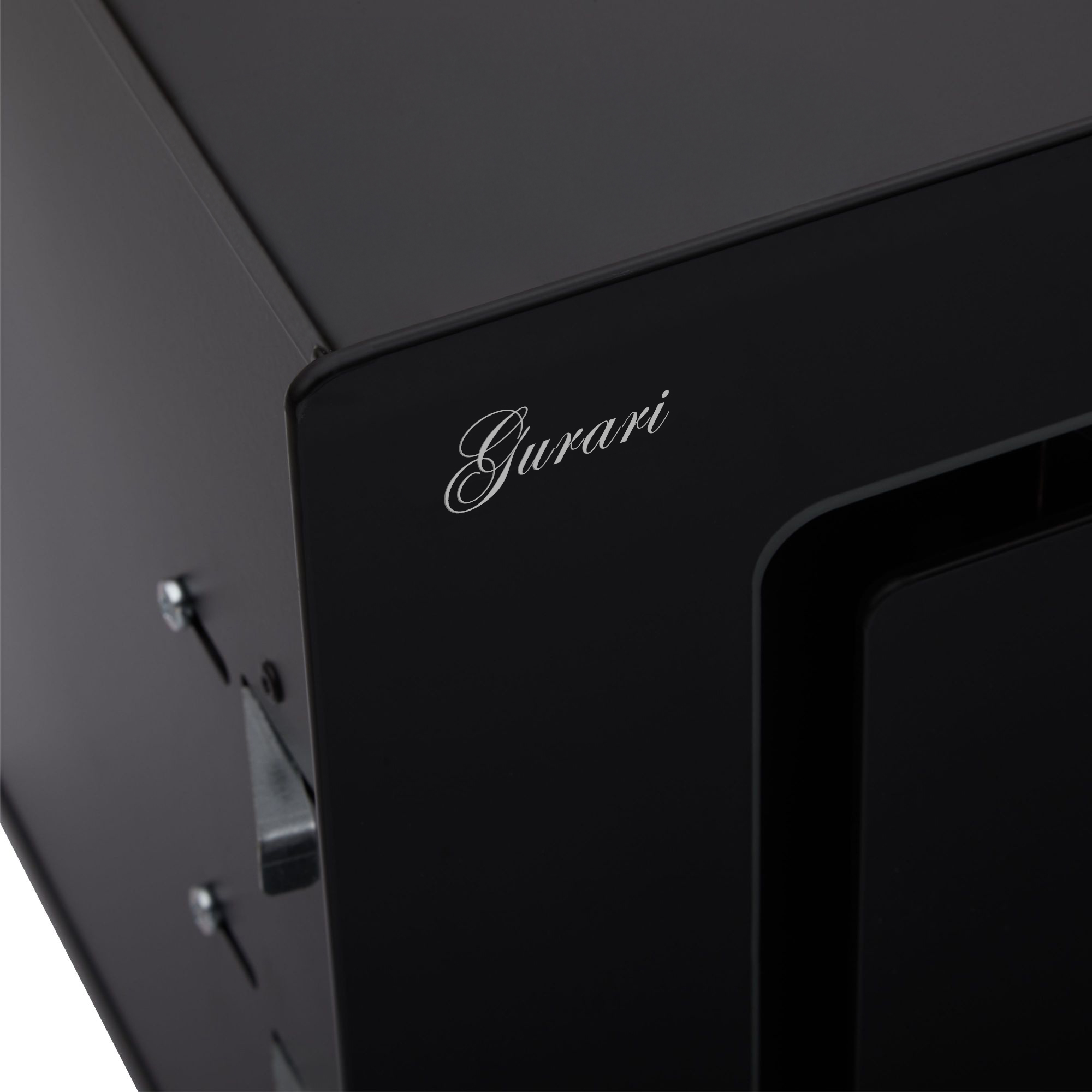 Nahaufnahme eines schwarzen Geräts mit dem Wort 'Gurari' in Schreibschrift. Schrauben und Metallteile sind sichtbar.