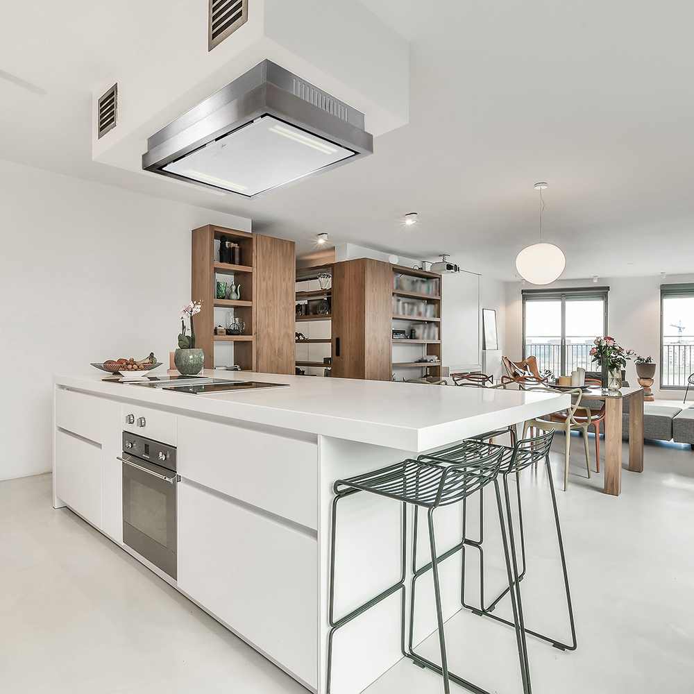 Moderne Küche mit weißer Insel, Metallhockern und Holzschränken. Im Hintergrund ist ein Essbereich mit großem Fenster zu sehen.