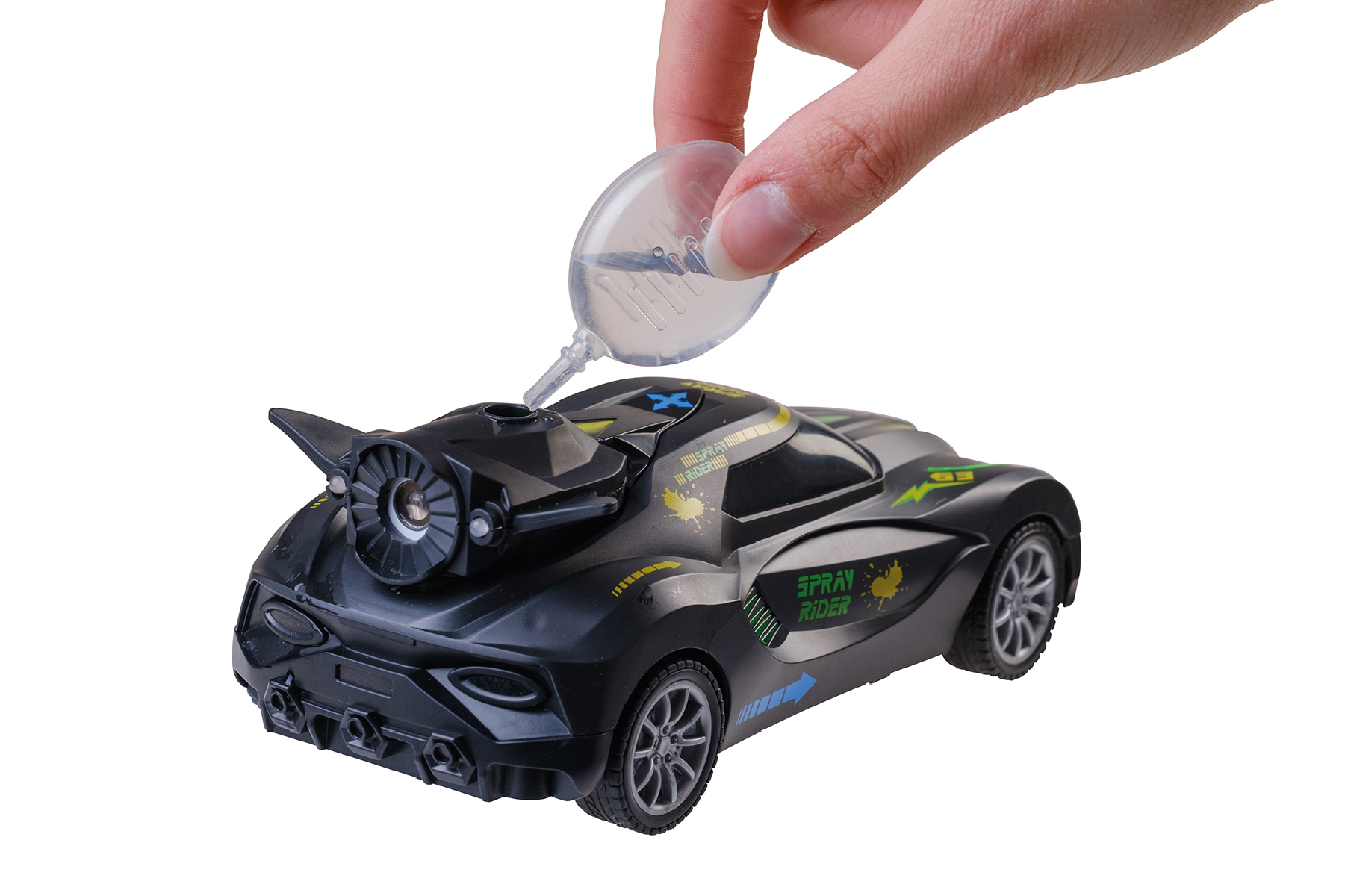 Eine Hand gießt Flüssigkeit in ein schwarzes Spielzeugauto mit grünen und gelben Akzenten. Das Auto hat ein Triebwerk-Design.