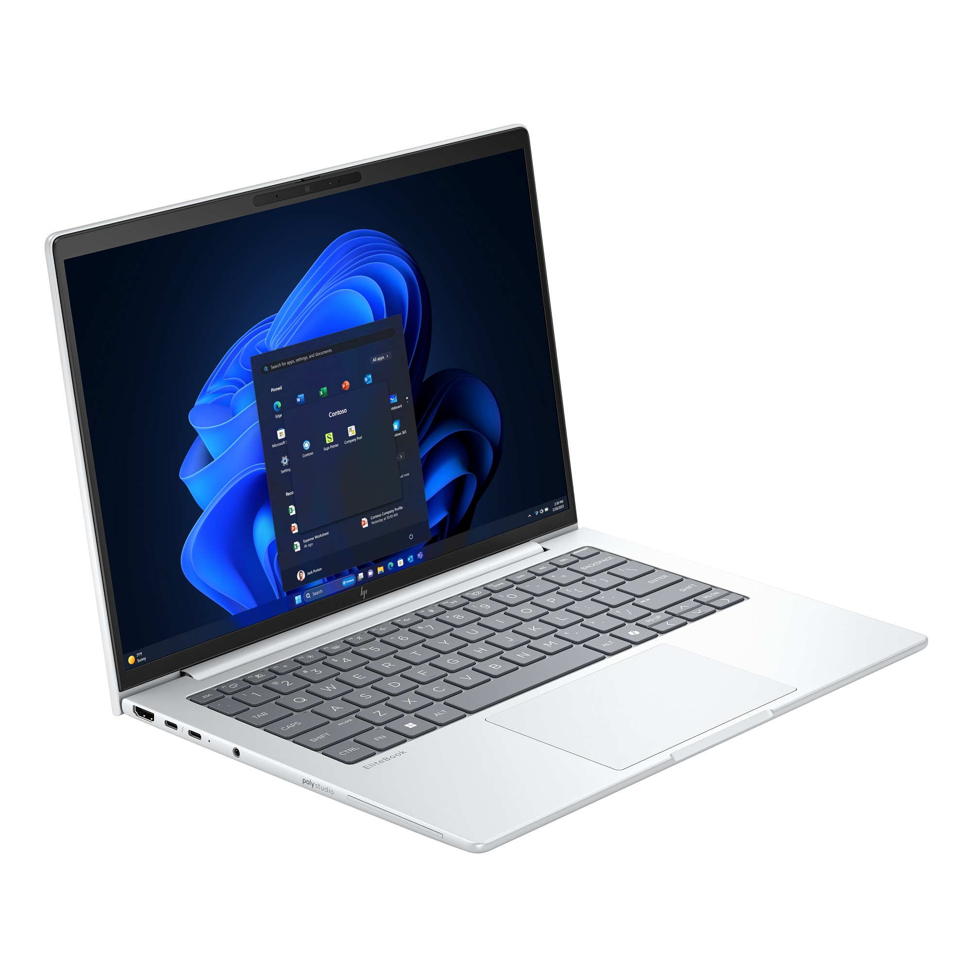 Portátil plateado sobre fondo blanco, pantalla muestra interfaz Windows. Teclado y panel táctil visibles. Apps abiertas.
