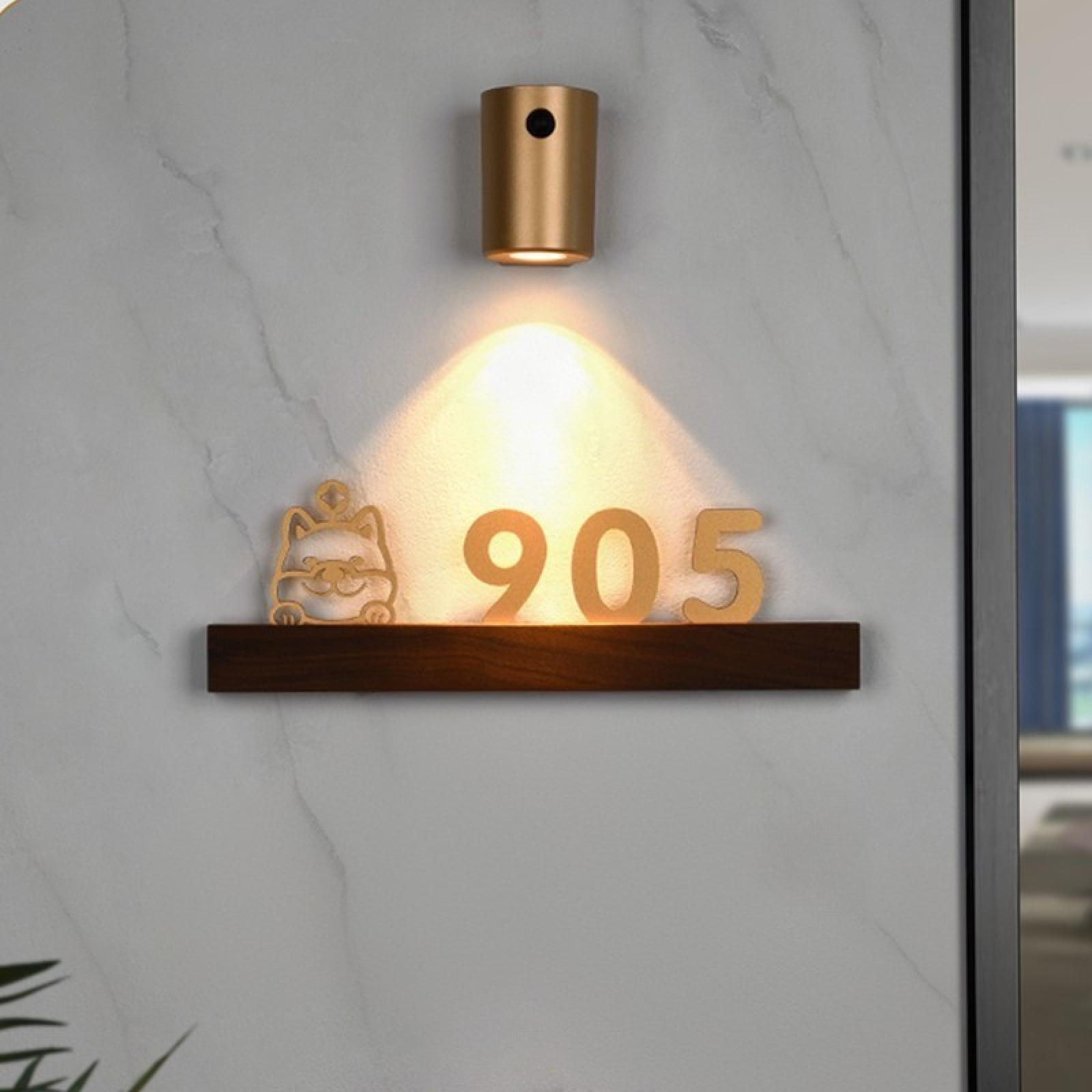 Ein Wandzeichen mit der Nummer 905, einem Katzendesign und einem Scheinwerfer. Die Wand ist marmoriert.