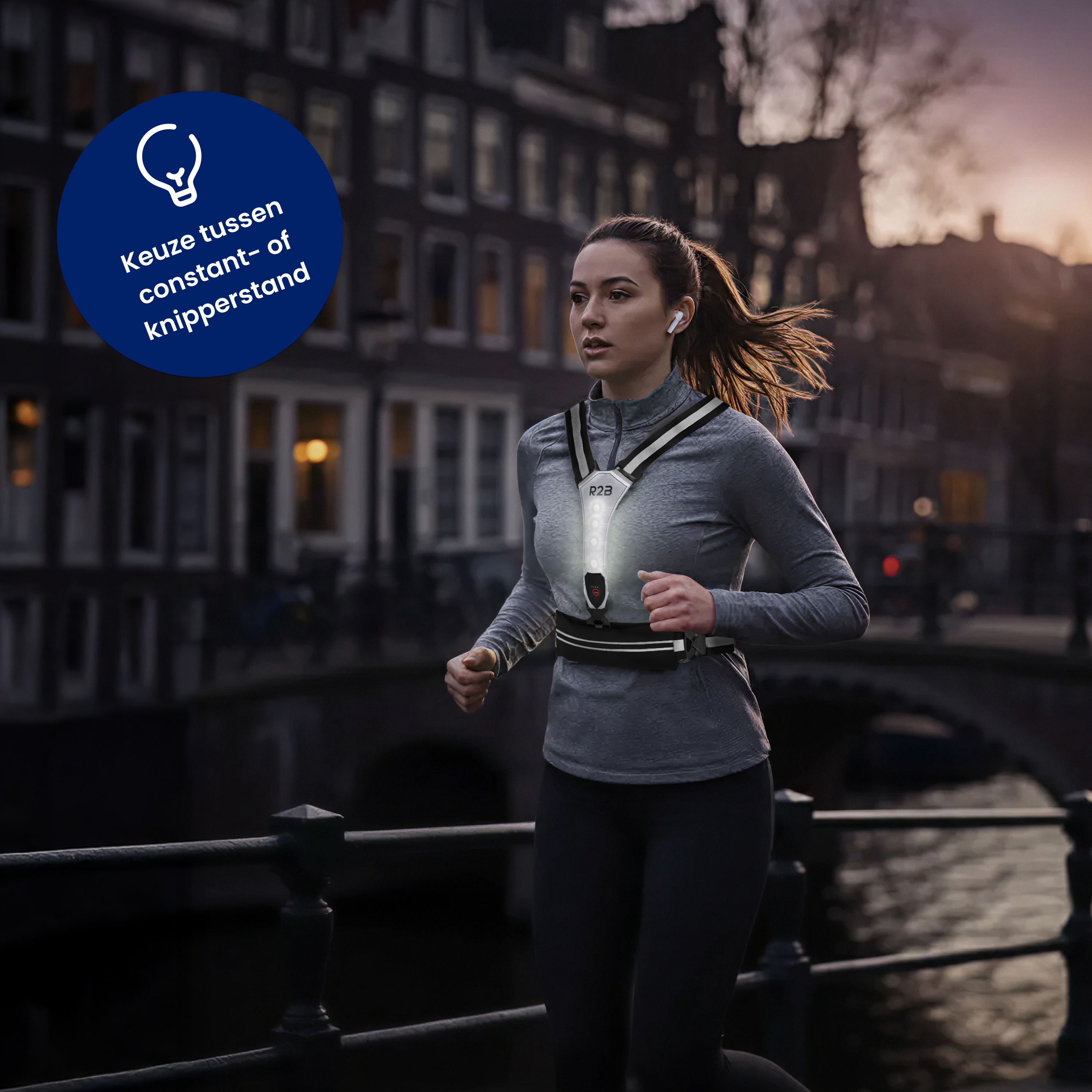 A woman runs at night, wearing a reflective vest. Buildings and a canal are in the background. A light is on.