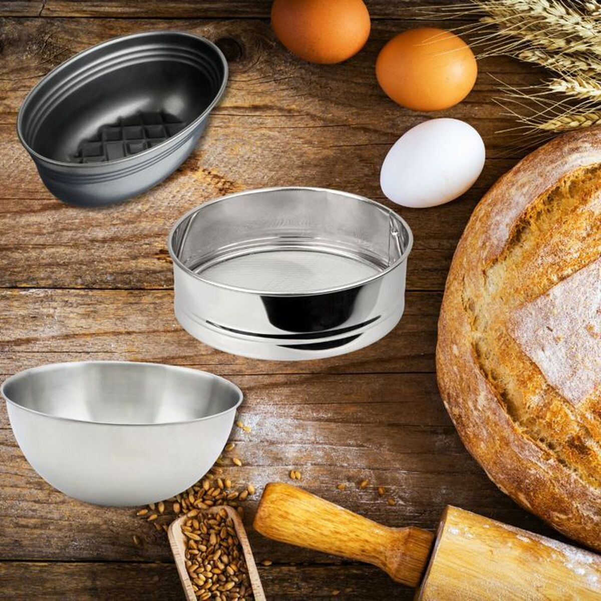 Backszene: Brotlaib, Eier, Schüsseln, Sieb und Nudelholz auf Holz. Weizen und Körner sind sichtbar.