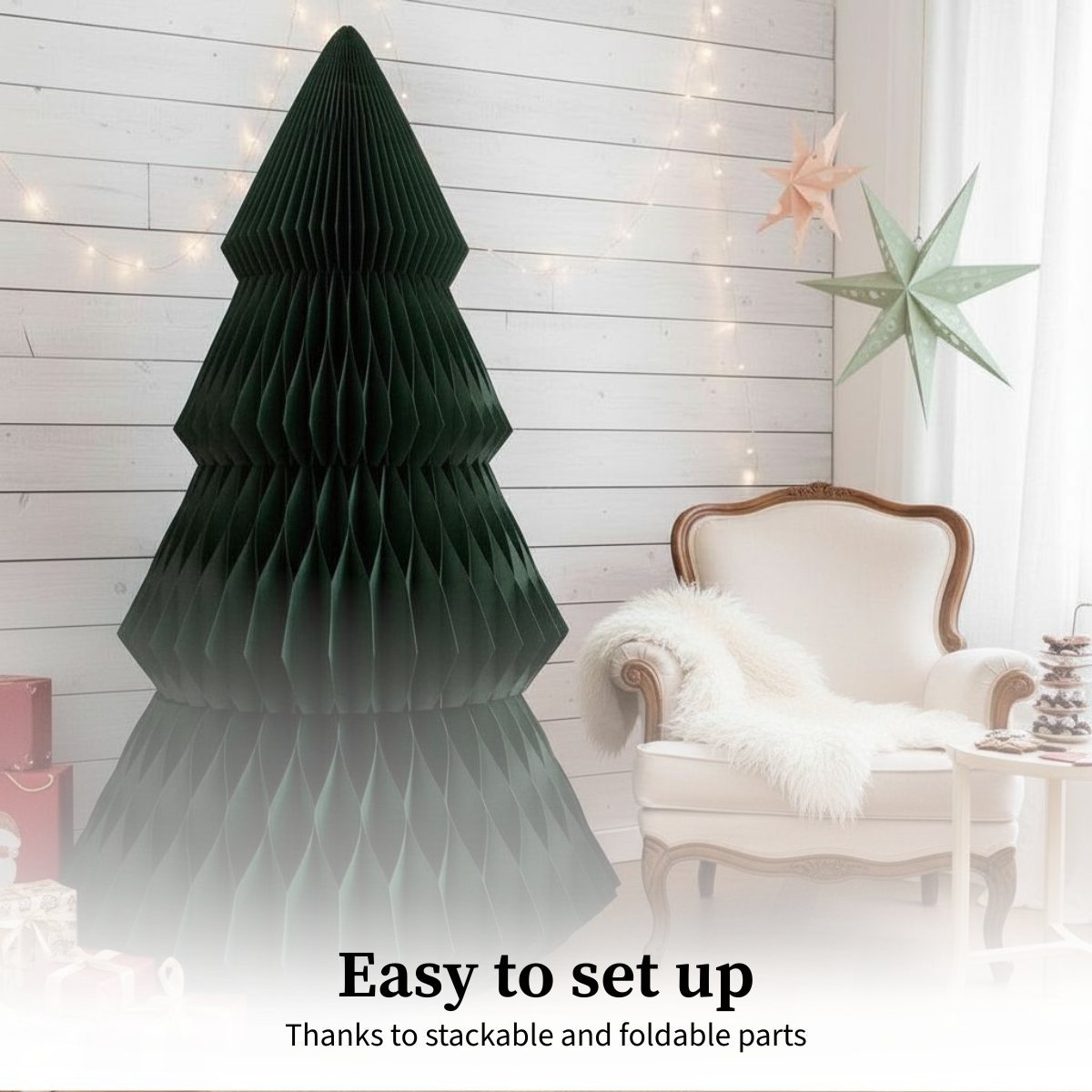 Un sapin de Noël en papier vert foncé se trouve près d'un fauteuil blanc avec une couverture moelleuse. Des étoiles en papier sont accrochées au mur.