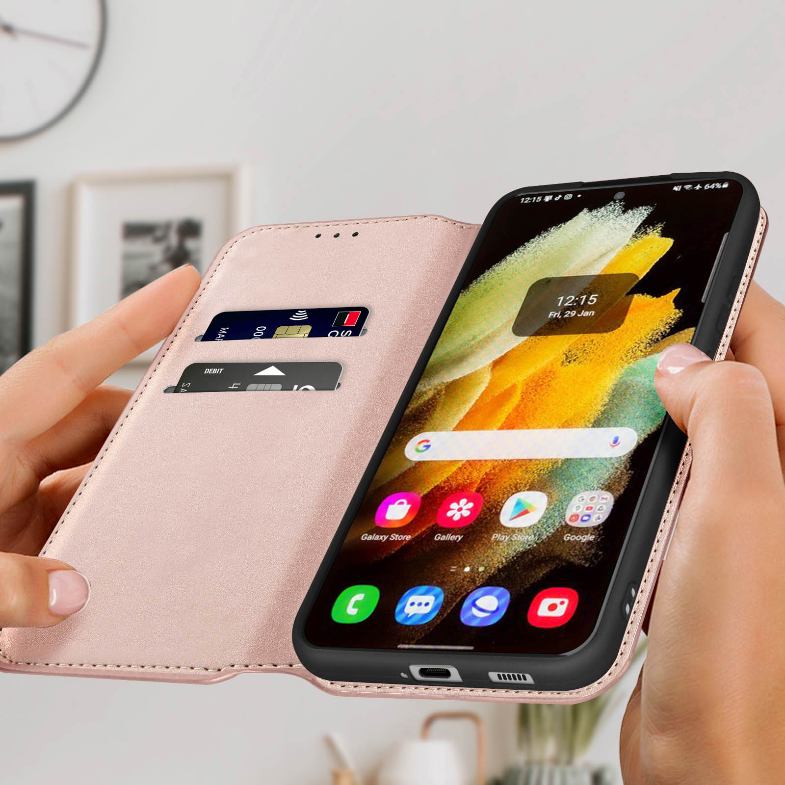 Un téléphone dans un étui rose est tenu ouvert. L'écran affiche l'heure et les icônes d'applications. Des cartes de crédit sont visibles.