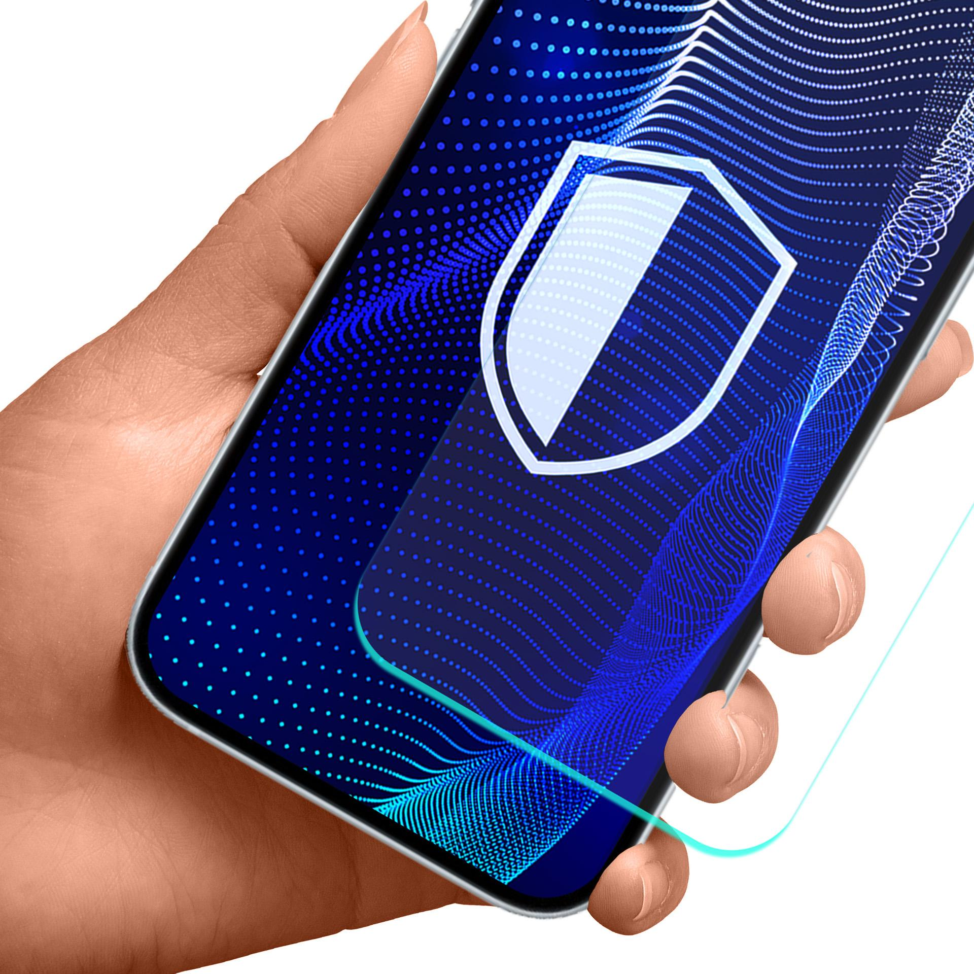 Dłoń trzymająca smartfon z ikoną tarczy na ekranie. Tło jest białe.