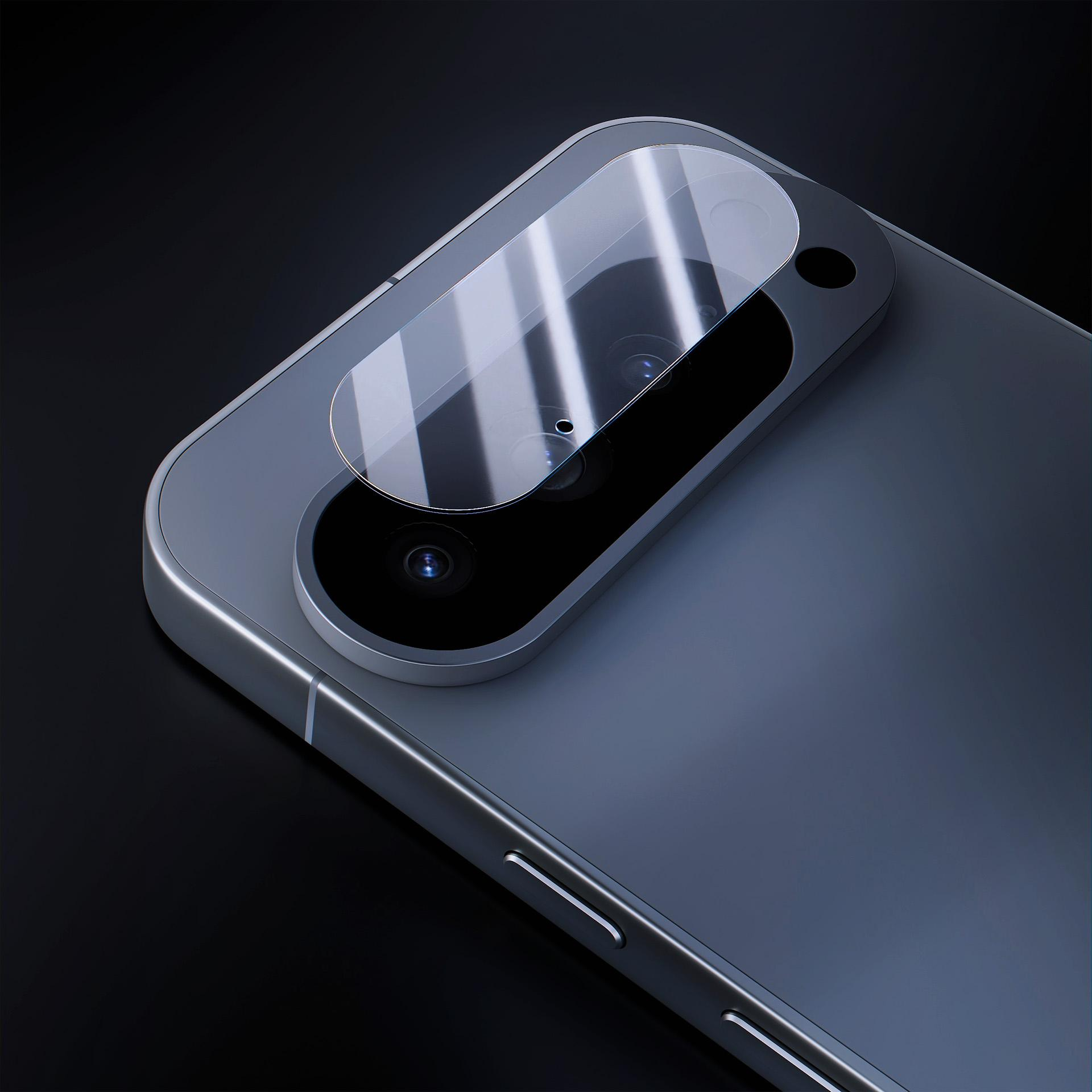 Retro di uno smartphone con protezione per fotocamera. Il telefono è grigio, lo sfondo è nero. La protezione è trasparente.