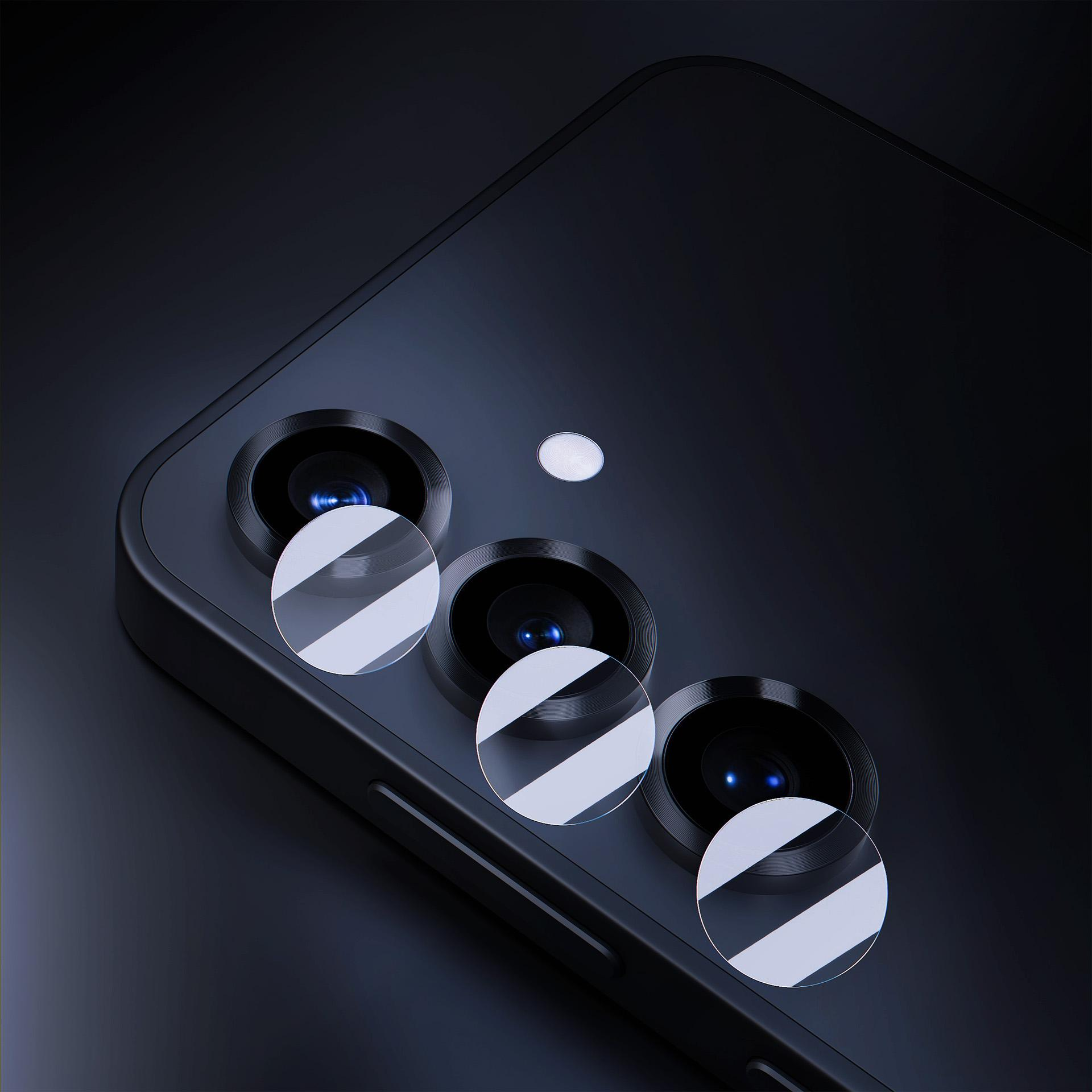Zbliżenie obiektywów aparatu w telefonie. Widoczne trzy obiektywy z osłonami. Telefon jest czarny, tło ciemne.