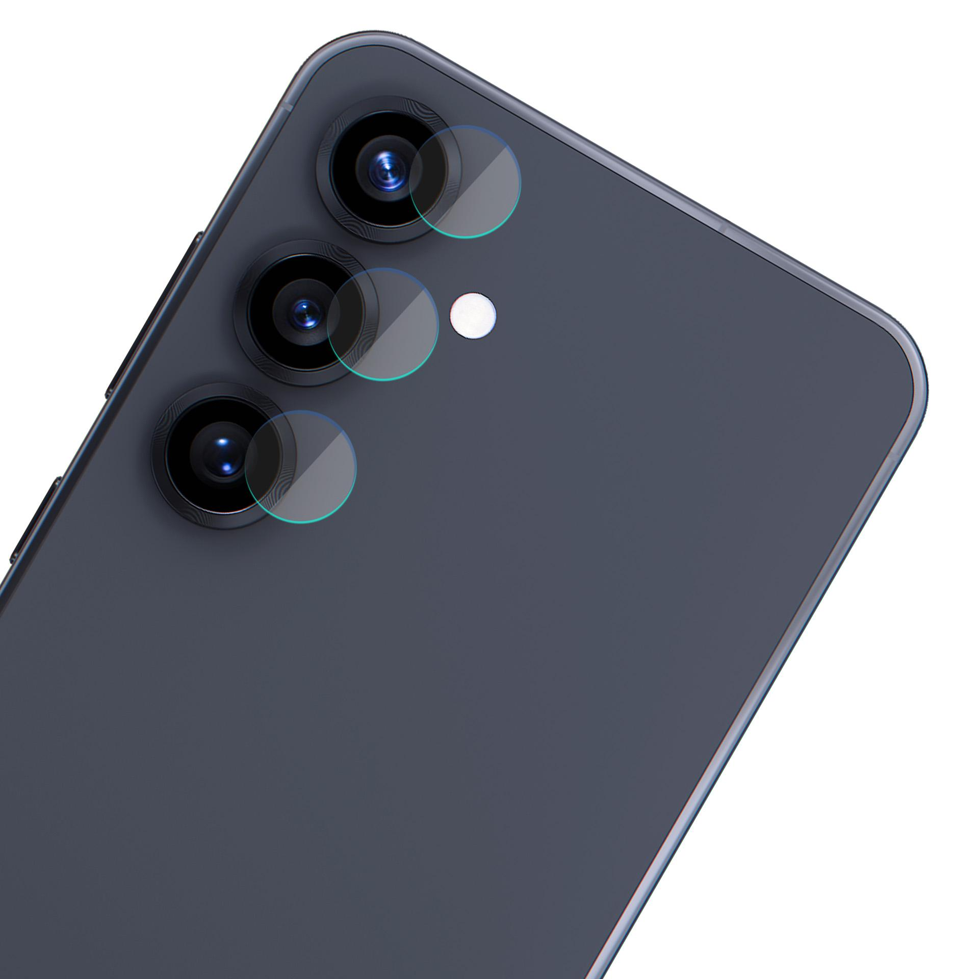 Ciemnoszary tył telefonu z trzema obiektywami aparatu, osłonami i małą białą kropką.