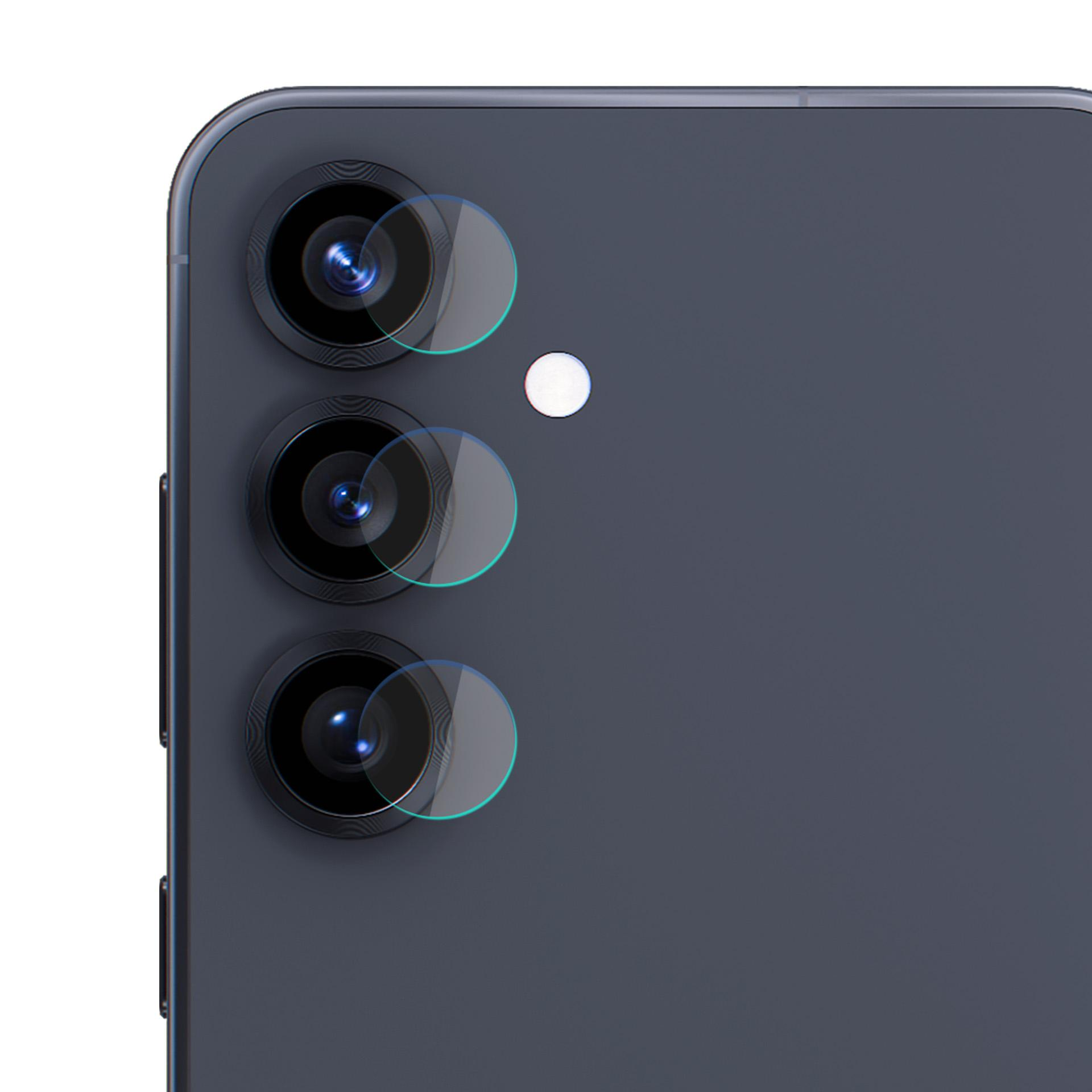 Zbliżenie na układ kamery telefonu. Widoczne trzy obiektywy z osłonami ochronnymi. Telefon ma ciemnoszary tył.