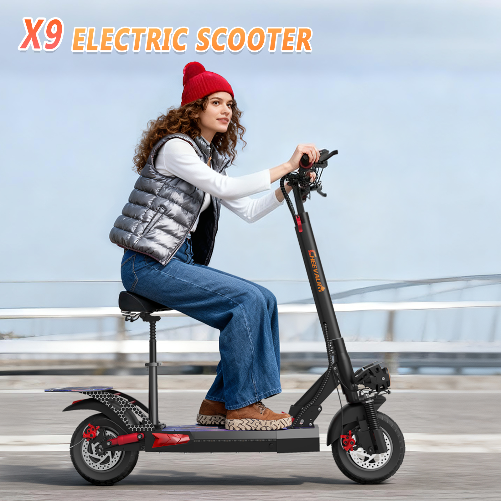 Kobieta w czerwonej czapce i kamizelce jedzie na czarnej hulajnodze elektrycznej. Jest na drodze z niebieskim tłem nieba.