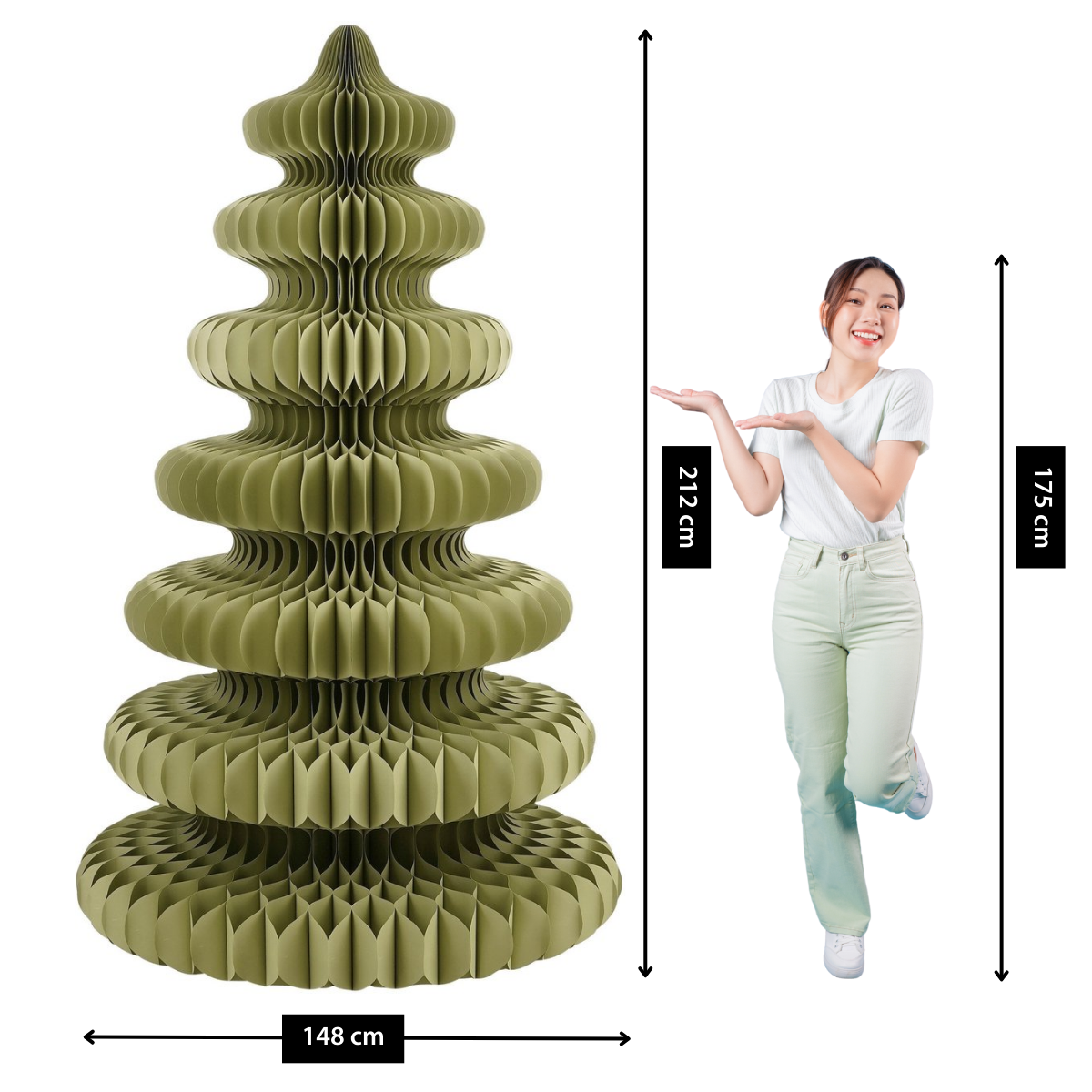 Une femme se tient à côté d'un grand sapin de Noël en papier vert olive. Des mesures sont affichées. La femme montre l'arbre.