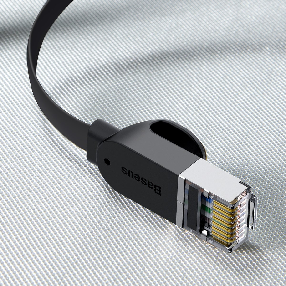 Un cavo ethernet nero Baseus con connettore trasparente. Si trova su una superficie grigio chiaro strutturata. Il cavo è angolato.