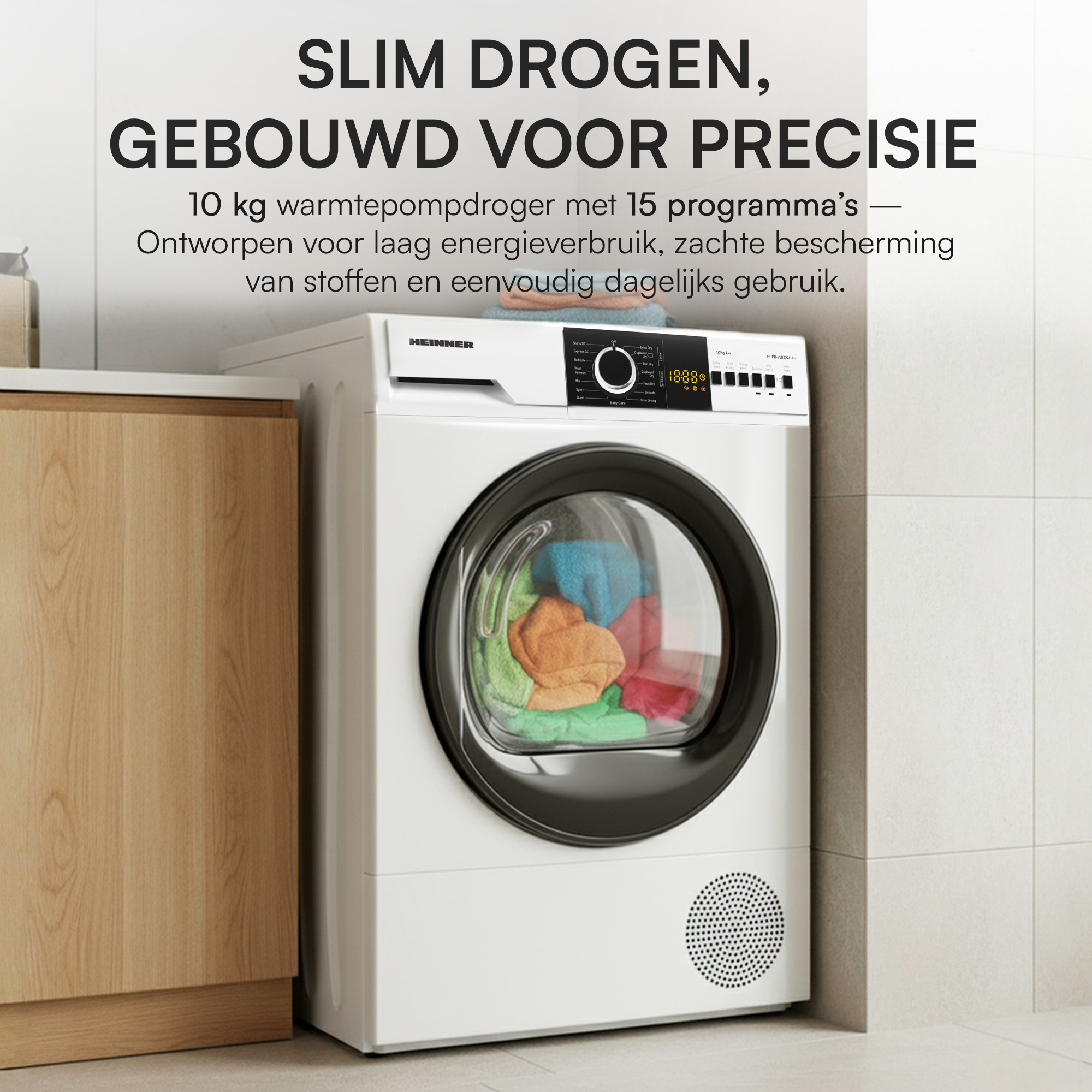 Ein weißer Trockner mit schwarzer Tür in einem Badezimmer. Bunte Kleidung im Trockner. Text über dem Trockner.