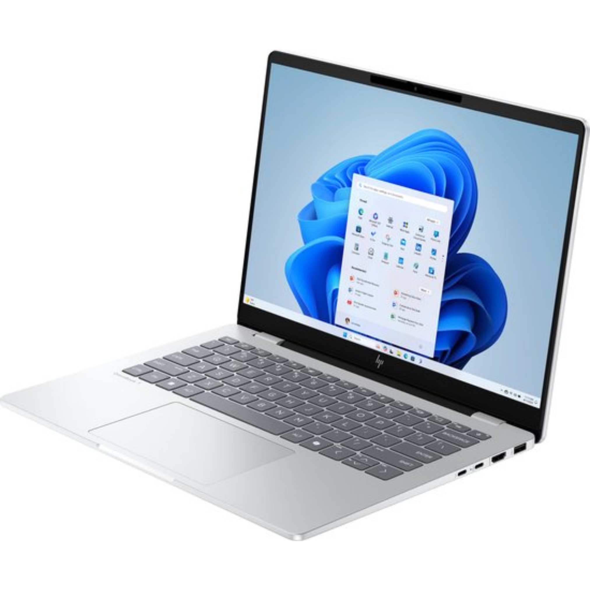 Silver laptop on white surface. The screen displays Windows interface with blue background. Keyboard is visible.