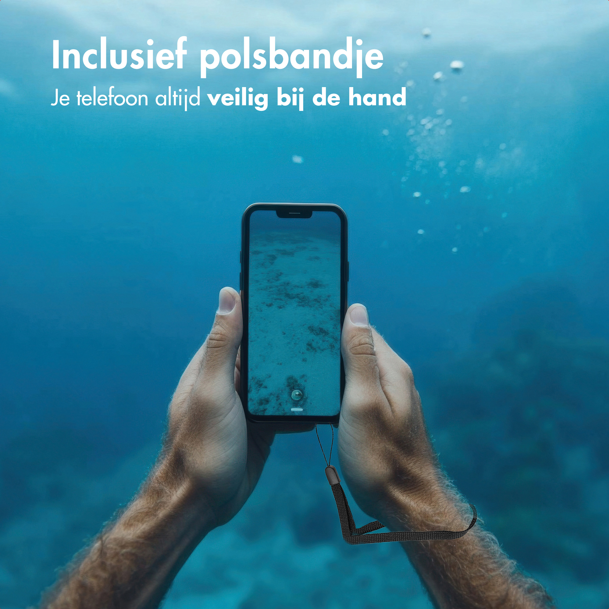 Handen die een telefoon onder water vasthouden. De telefoon heeft een polsbandje. De achtergrond is een blauwe zee. Tekst in het Nederlands.