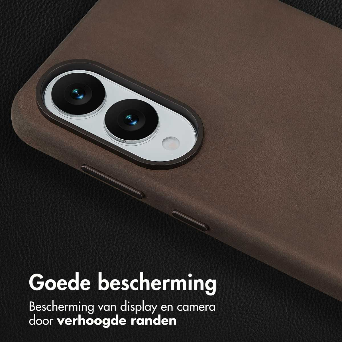 Close-up van een bruine telefoonhoes met cameralenzen. De hoes heeft verhoogde randen en goede bescherming. Achtergrond is donker leer.