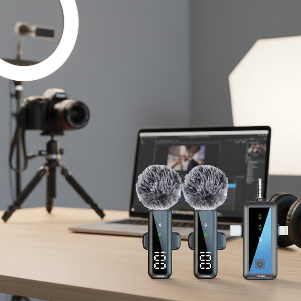 İki mikrofon, bir dizüstü bilgisayar ve bir tripod üzerinde bir kamera ile bir masa kurulumu. Bir halka ışık ve kulaklıklar da mevcut.