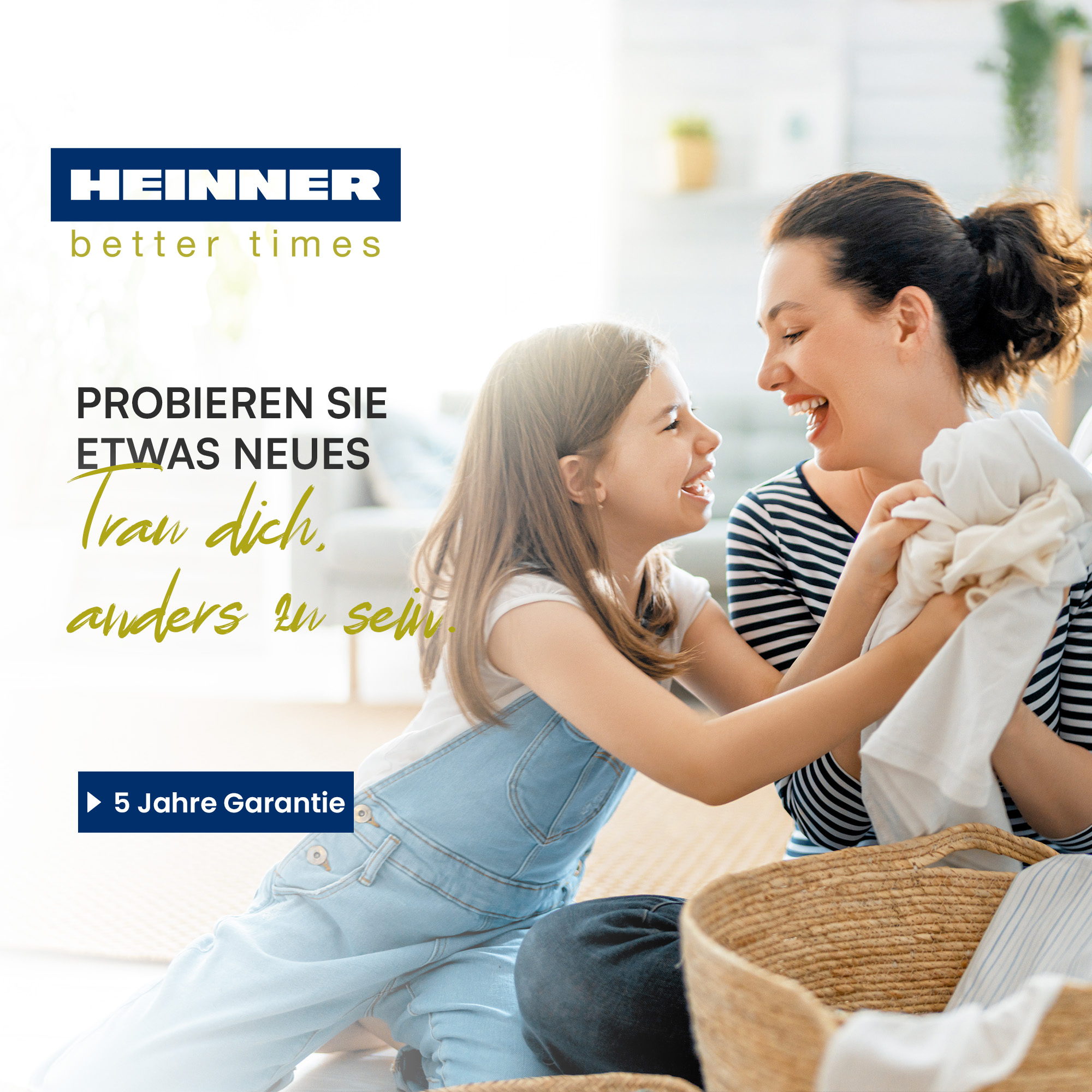 Mutter und Tochter lachen, halten Kleidung. Text: 'Probiere etwas Neues'. Ein Korb im Vordergrund. Heinner-Logo.
