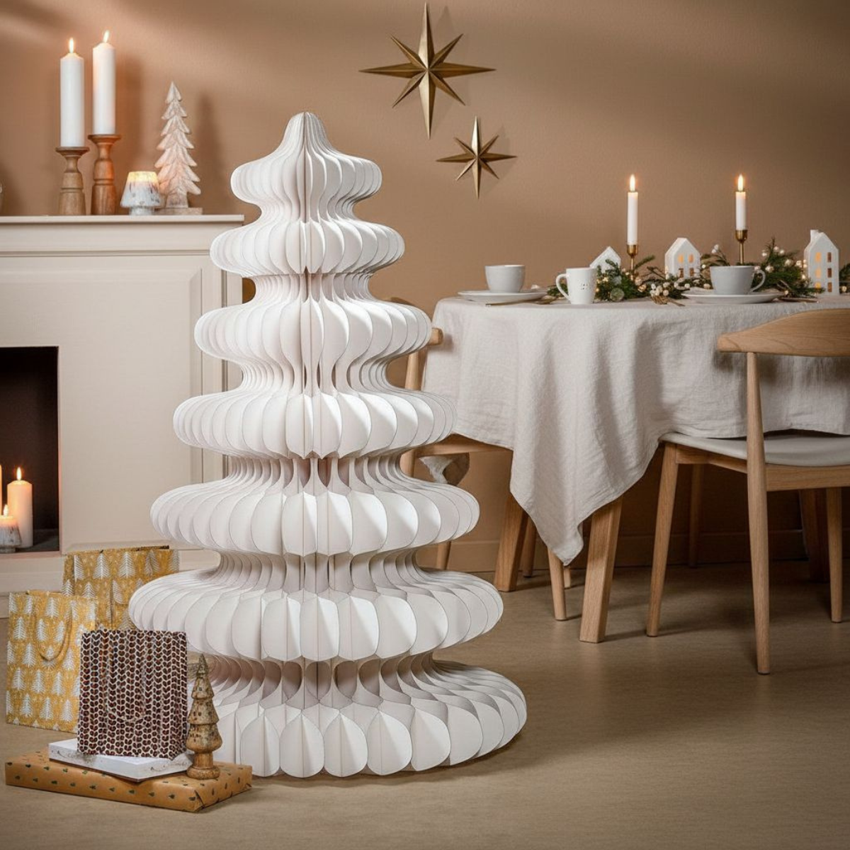 Un sapin de Noël en papier blanc se dresse devant une table. Des bougies, des cadeaux et des décorations en étoiles complètent la scène.