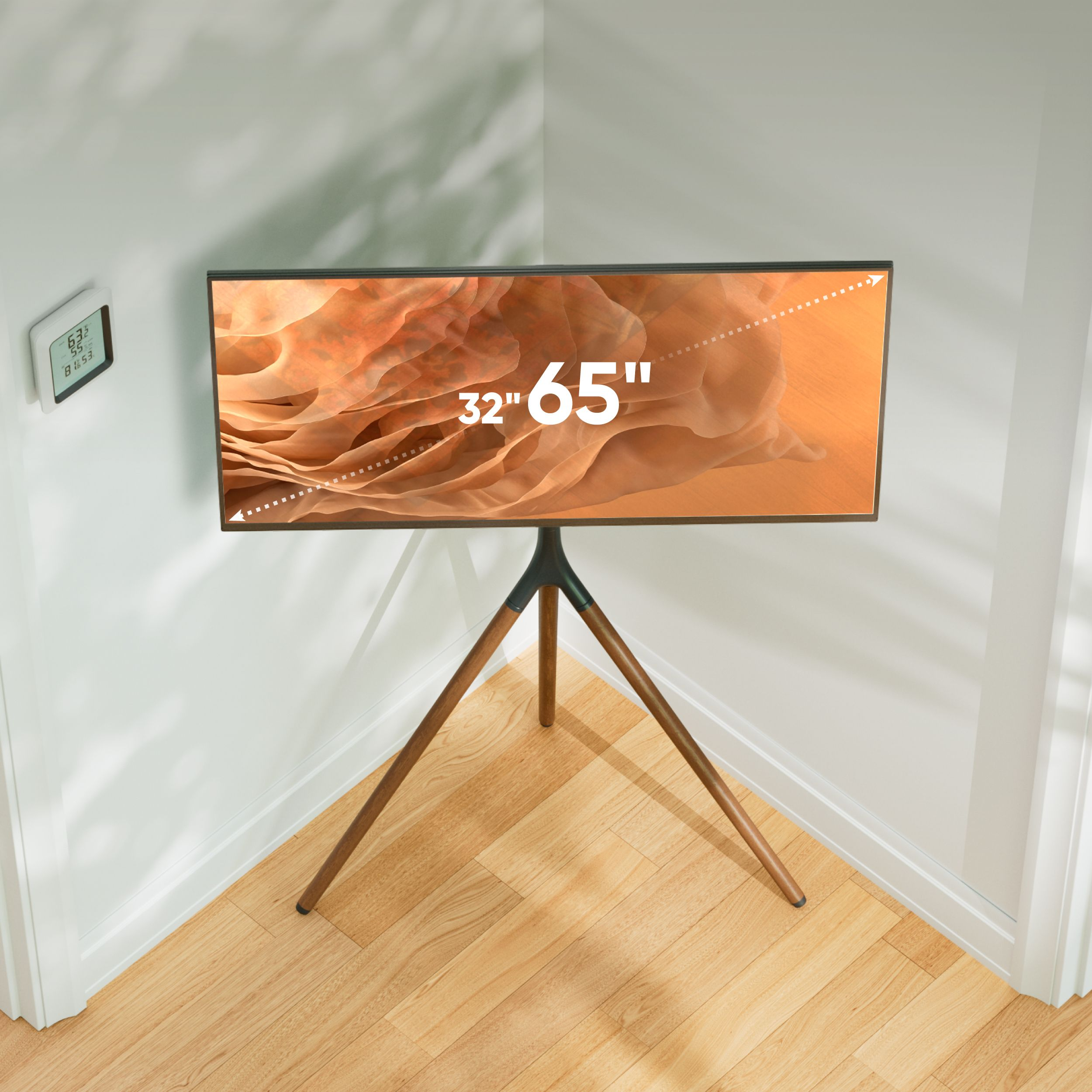 Telewizor 65-calowy na stojaku w rogu. Ekran wyświetla pomarańczowy abstrakcyjny wzór. Mała stacja pogodowa na ścianie.