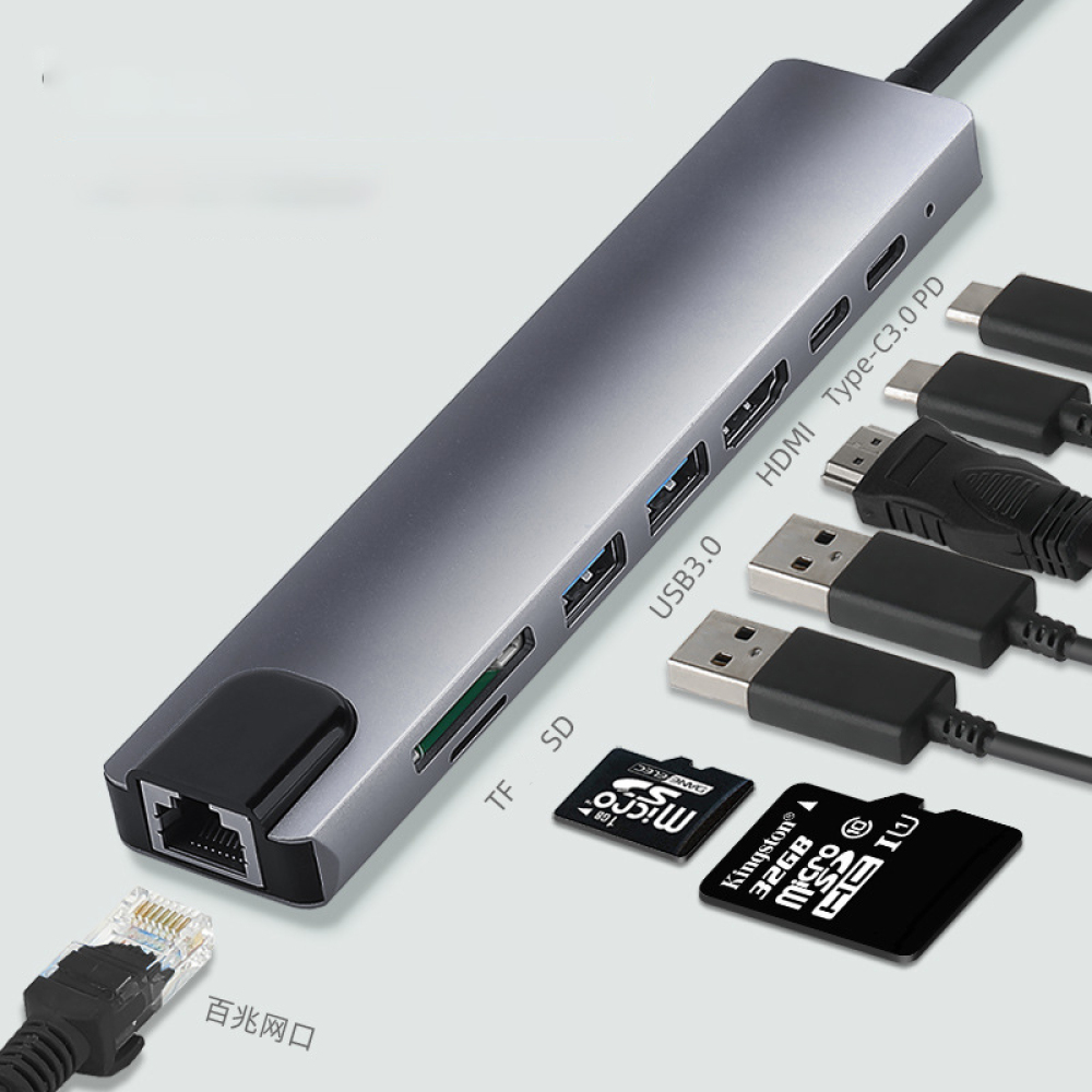 Ein grauer USB-Hub mit verschiedenen Anschlüssen, einschließlich HDMI, USB und SD-Karten-Steckplätzen, sowie angeschlossenen Kabeln und Speicherkarten.