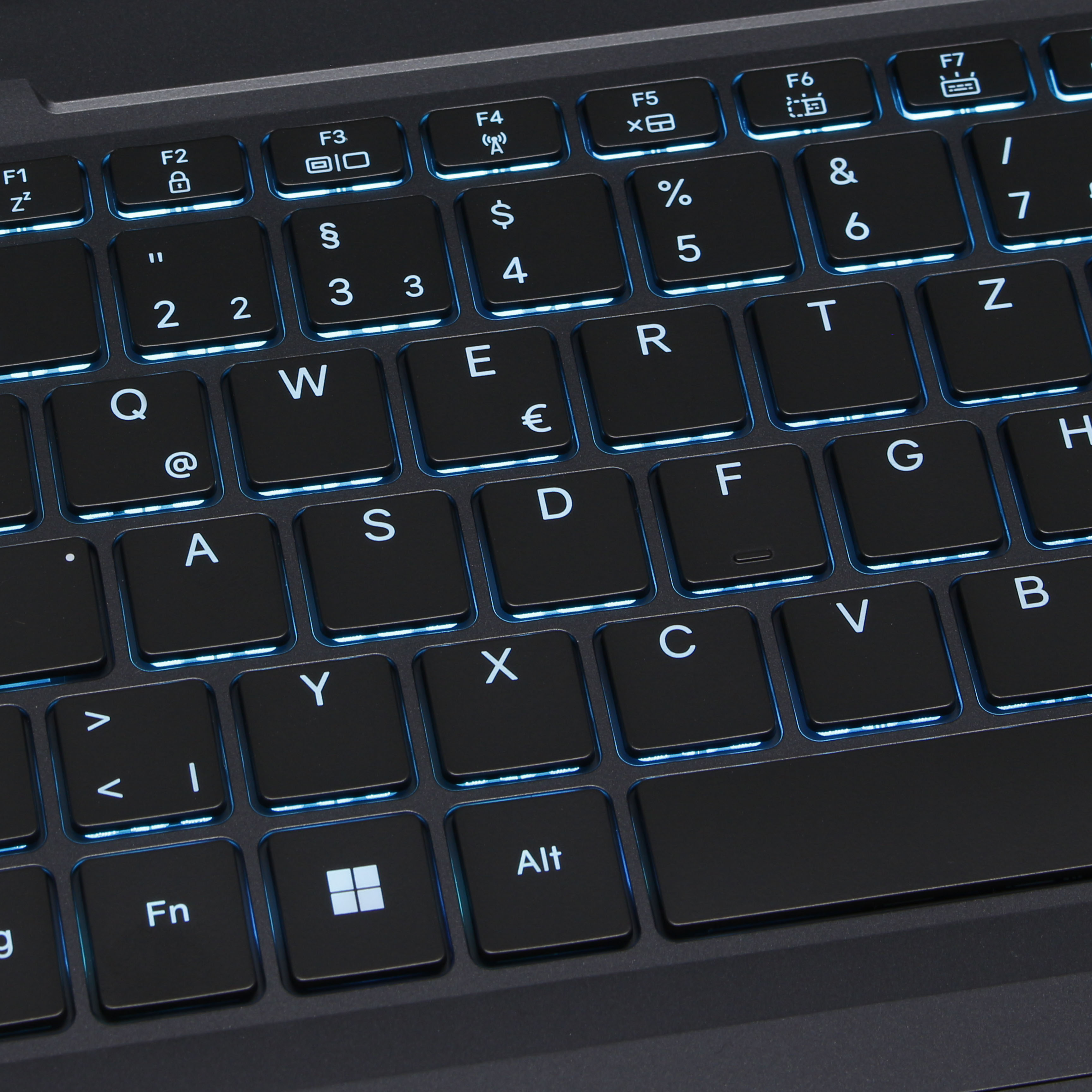 Nahaufnahme einer schwarzen Laptop-Tastatur mit beleuchteten Tasten. Buchstaben, Zahlen und Funktionstasten sichtbar.