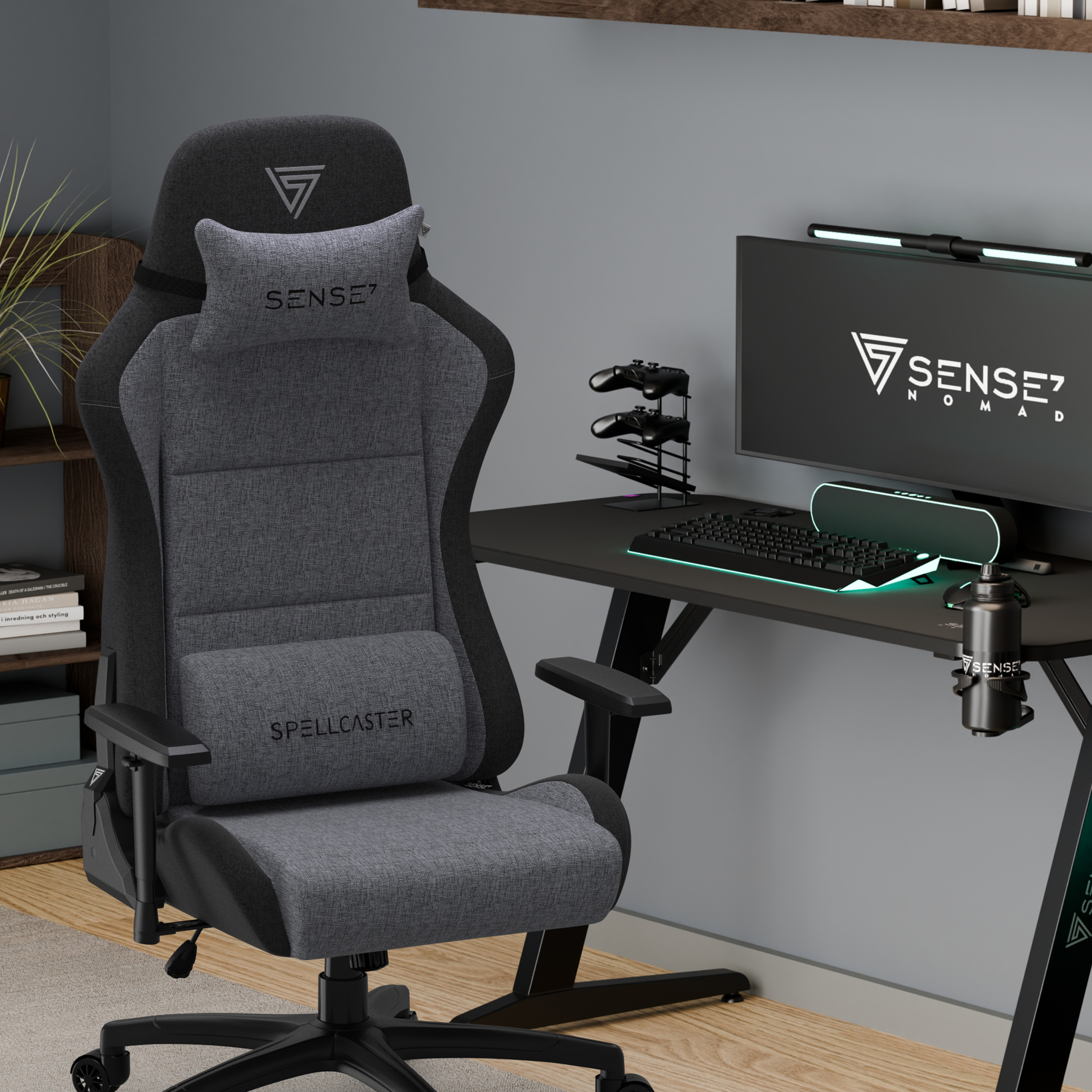 Een gaming-opstelling met een grijze stoel, bureau en monitor. De monitor toont het logo van Sense7 Nomad.