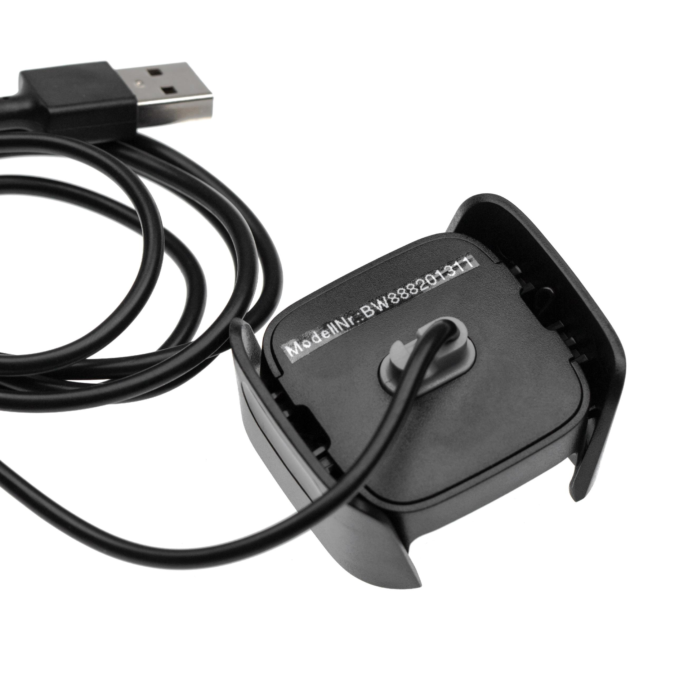 Ein schwarzes USB-Kabel und eine Ladestation auf weißem Hintergrund. Die Station hat eine Modellnummer.