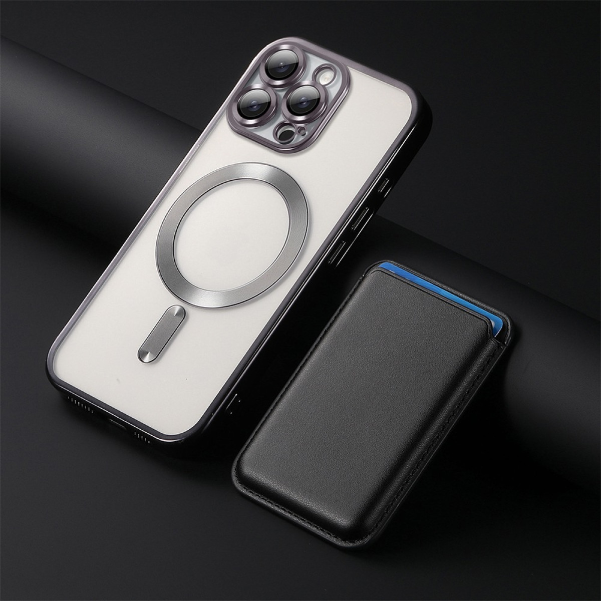 Una custodia per telefono e un porta carte su una superficie scura. La custodia è bianca con un anello metallico e lenti.