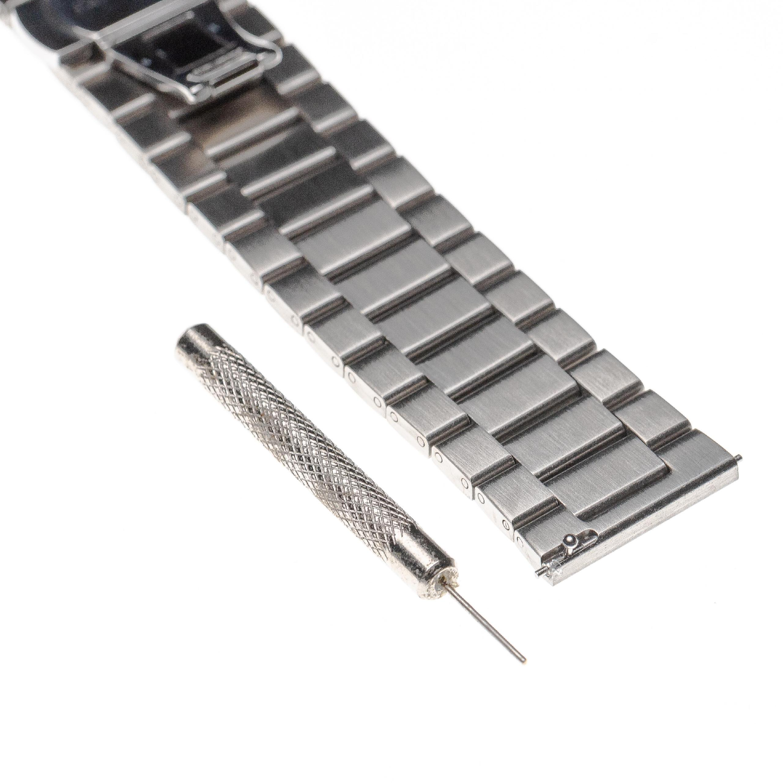 Ein Metall-Uhrenarmband und ein Stiftausdrückwerkzeug liegen auf einer weißen Oberfläche. Das Band ist silberfarben und abgewinkelt.