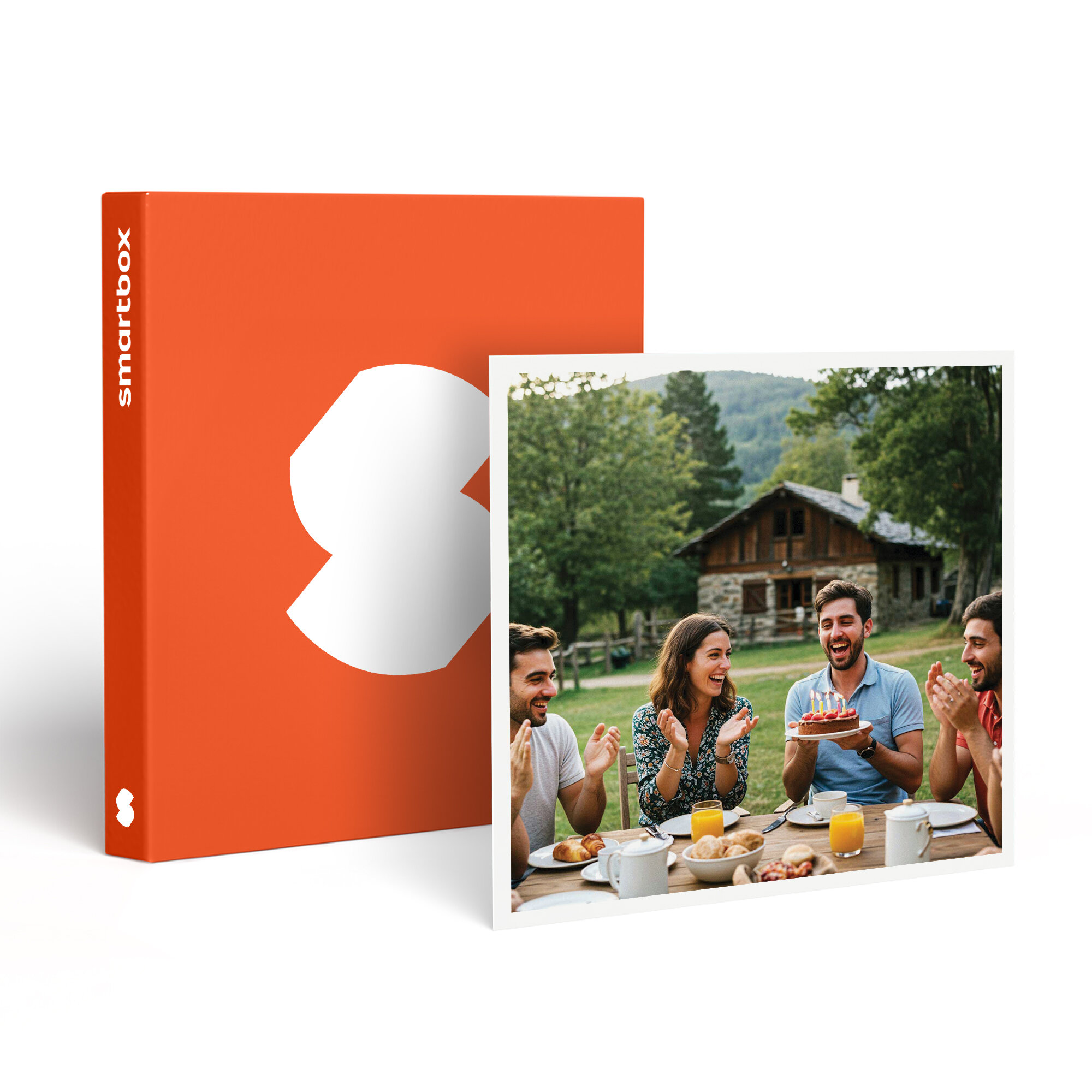 Celebración de cumpleaños al aire libre. Gente alrededor de una mesa con pastel. Caja naranja con logo blanco.