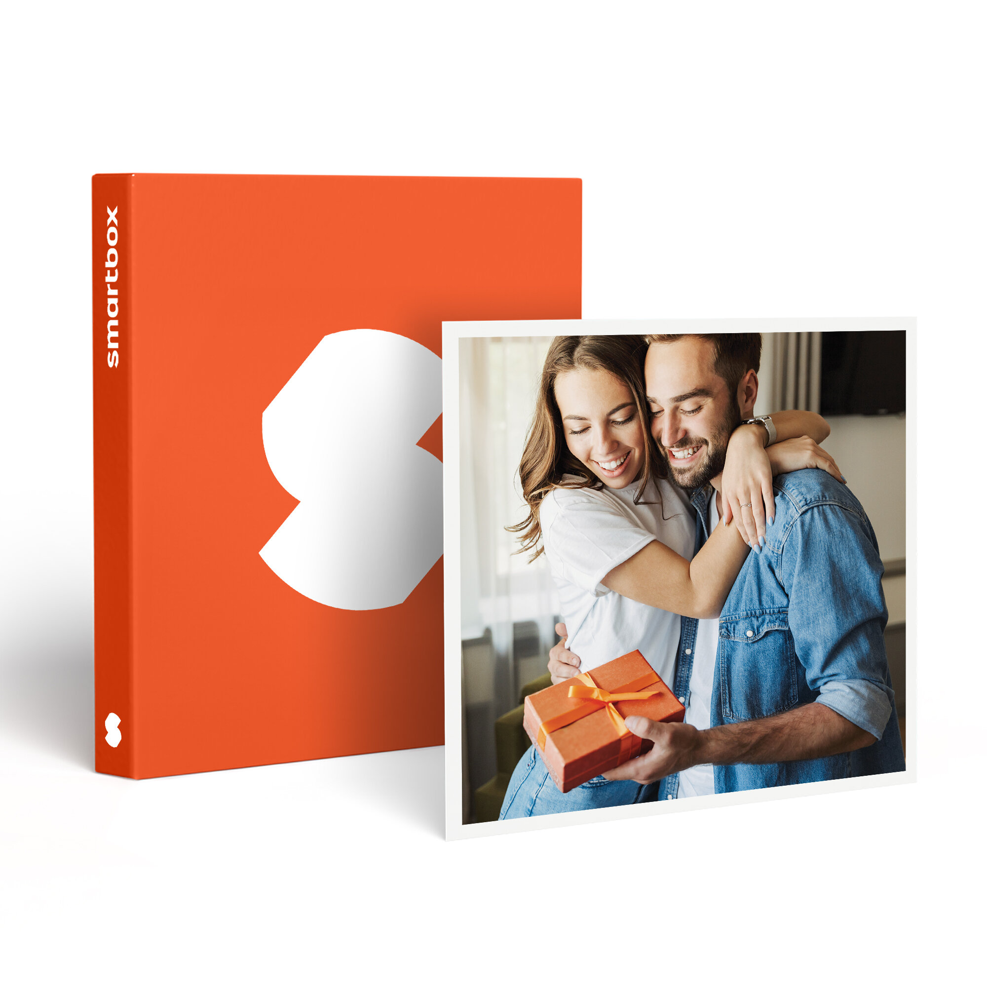 Una pareja se abraza recibiendo un regalo. A la izquierda, una caja naranja con un logotipo blanco.