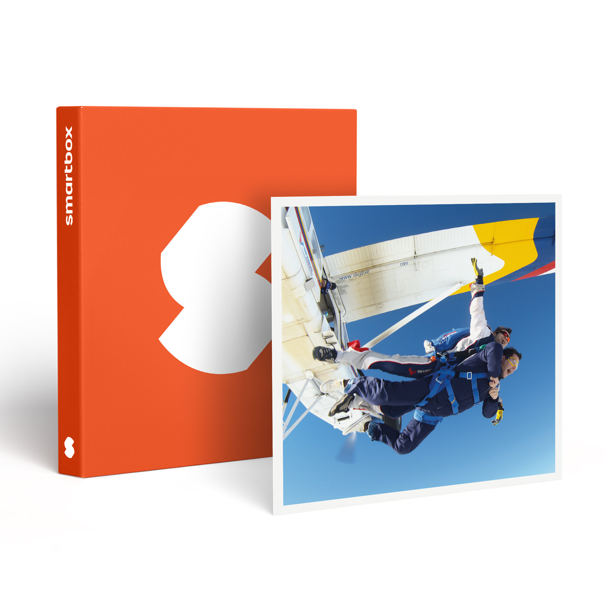 Dos personas saltando en paracaídas, cielo azul claro. Una caja naranja con un logo blanco a la izquierda.