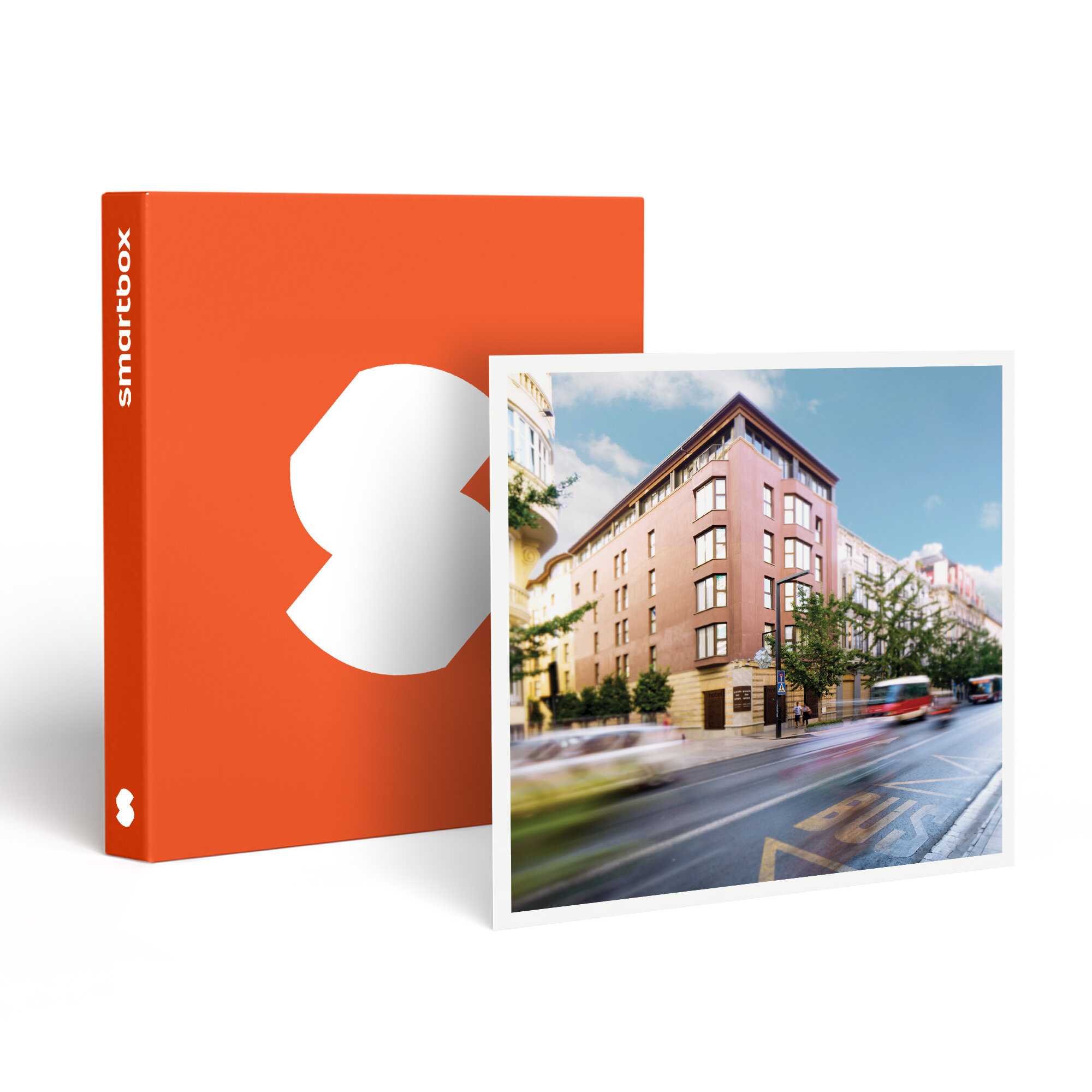 Una caja naranja con un diseño blanco. Una foto muestra un edificio y una carretera con autobuses borrosos.
