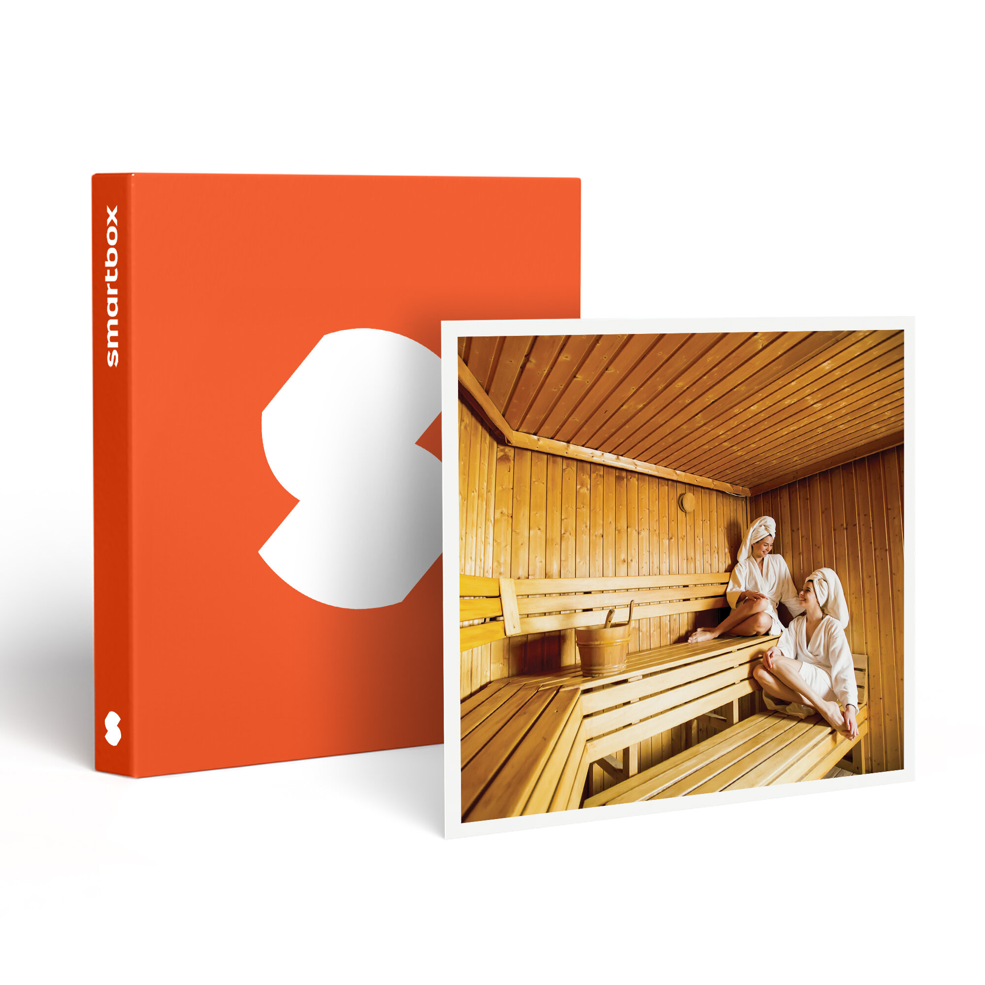 Dos mujeres en una sauna, con batas y toallas. Interior de madera, caja naranja en el fondo con la palabra smartbox.