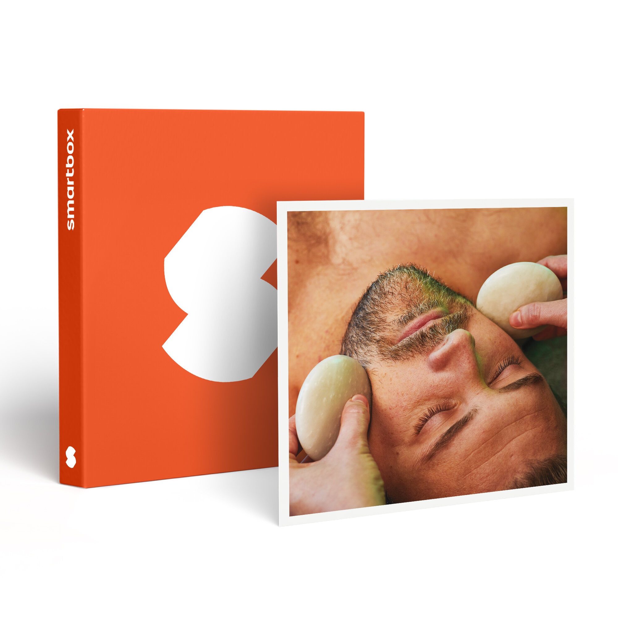 Un hombre recibiendo un tratamiento facial con piedras lisas. A la izquierda, una caja naranja con un logotipo blanco.