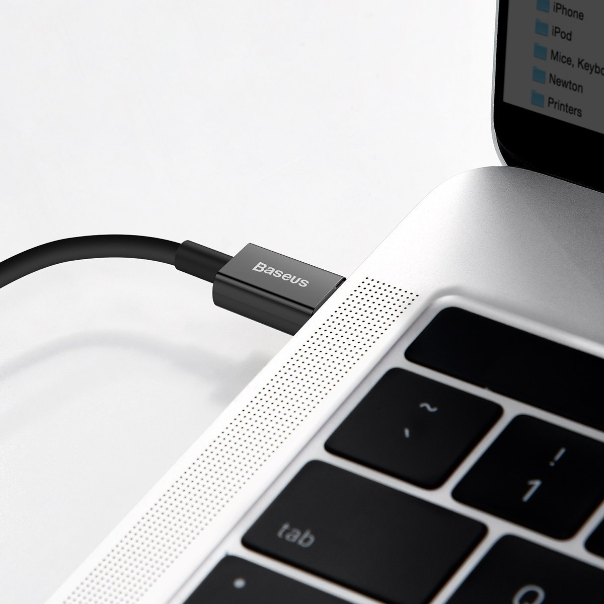 Czarny kabel USB-C Baseus jest podłączony do srebrnego laptopa. Widoczna jest również klawiatura i ekran.