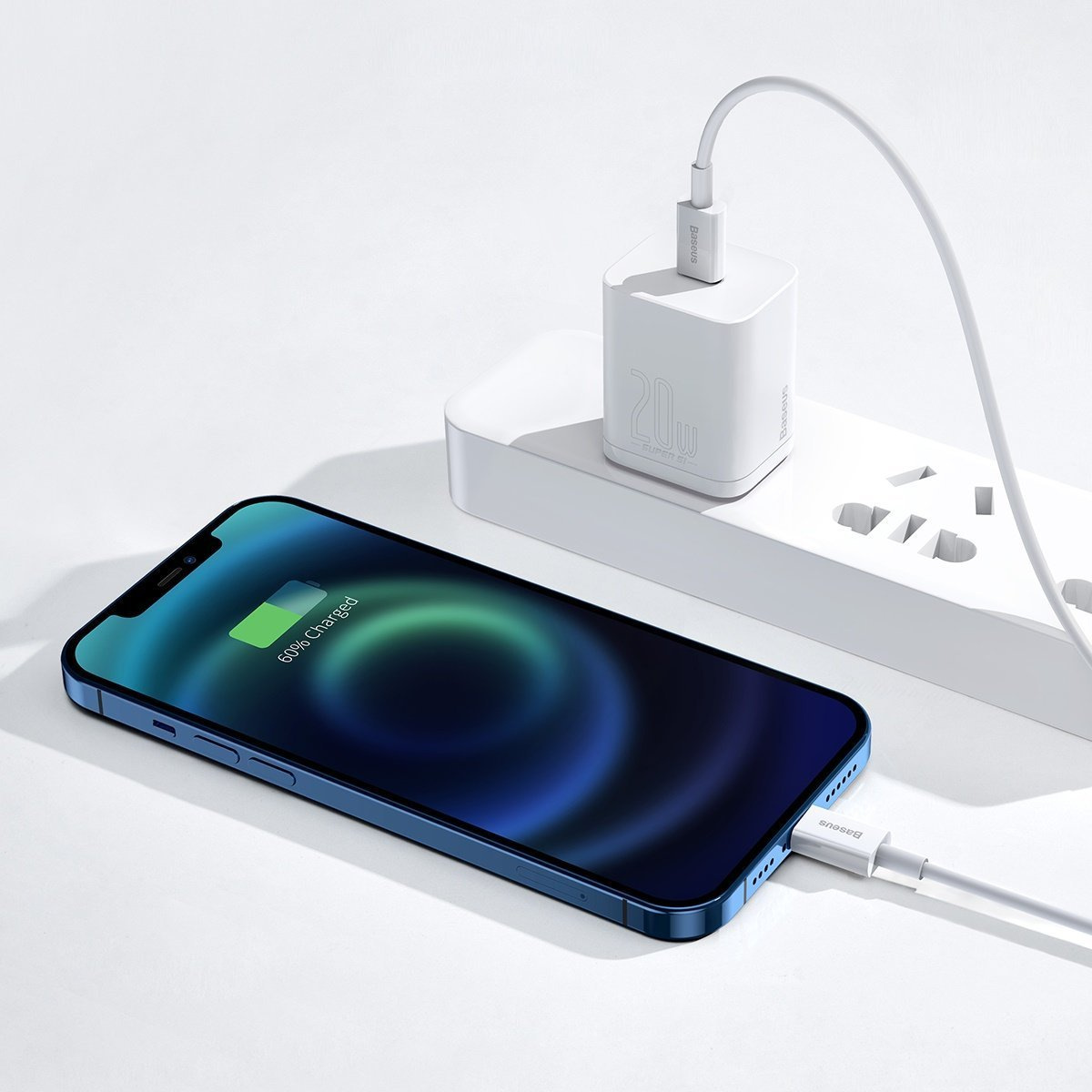 Un telefono blu si sta caricando con un caricabatterie bianco. Il telefono mostra il 60% di carica. Il caricabatterie è collegato a una presa multipla bianca.