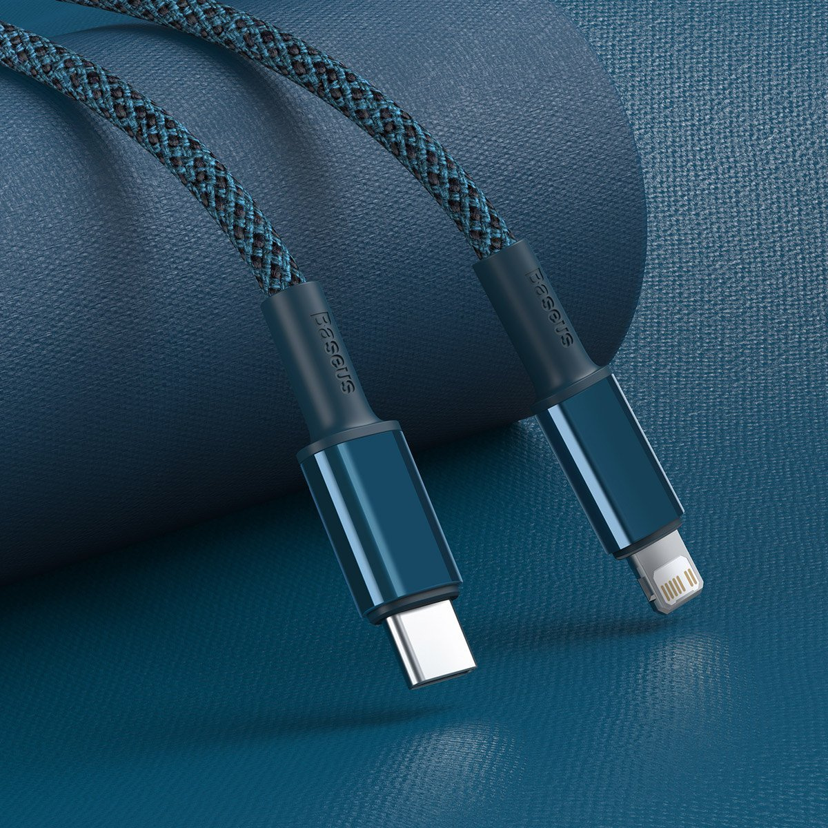 Deux câbles USB bleus tressés avec la marque Baseus. L'un a un connecteur USB-C, l'autre un connecteur iPhone, sur une surface bleue.