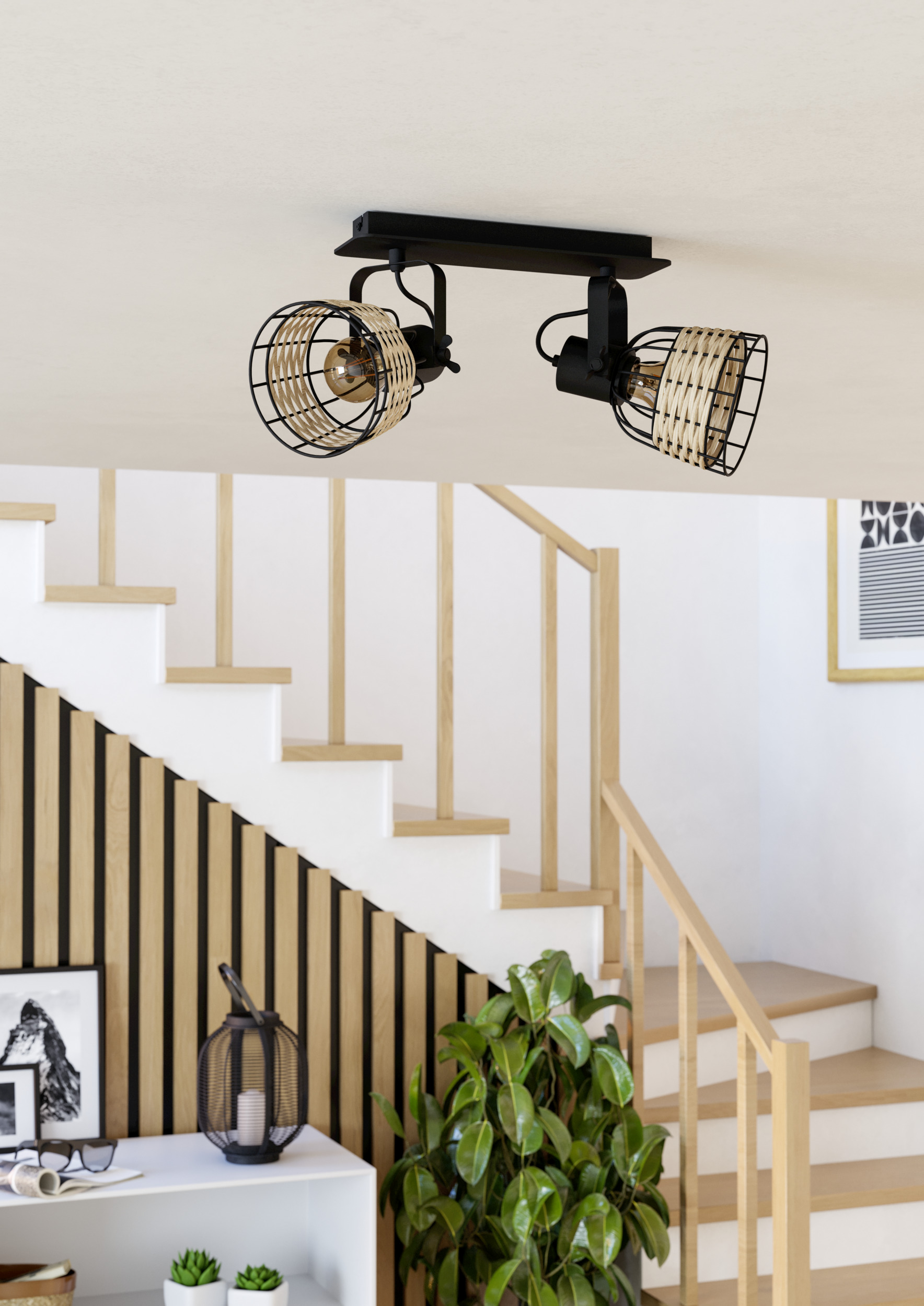 Plafonnier avec deux lampes, escalier et plante d'intérieur.