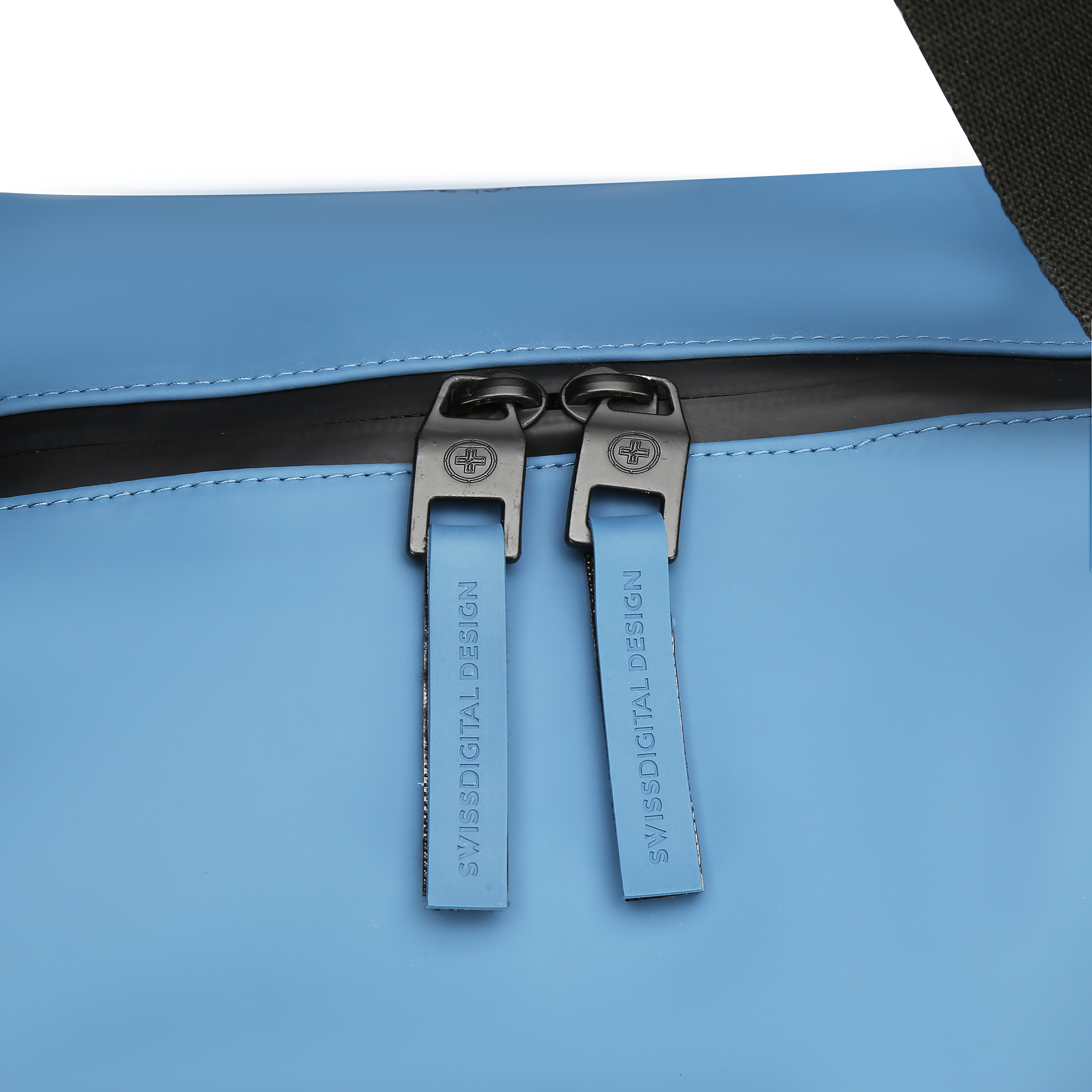 Primo piano di una borsa azzurra con cerniere nere e le parole 'SWISSDIGITAL DESIGN' sulle zip.